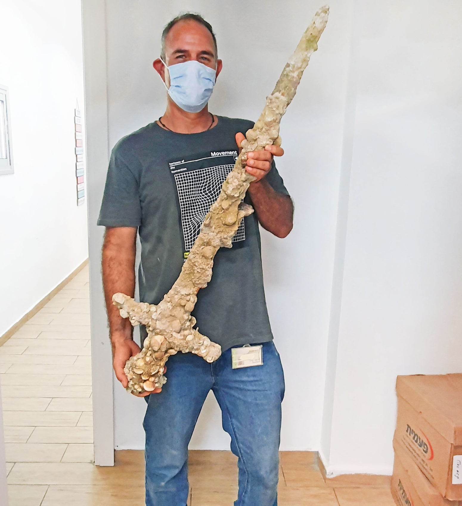 Scuba diver Shlomi Katzin brandishing the sword he found. 