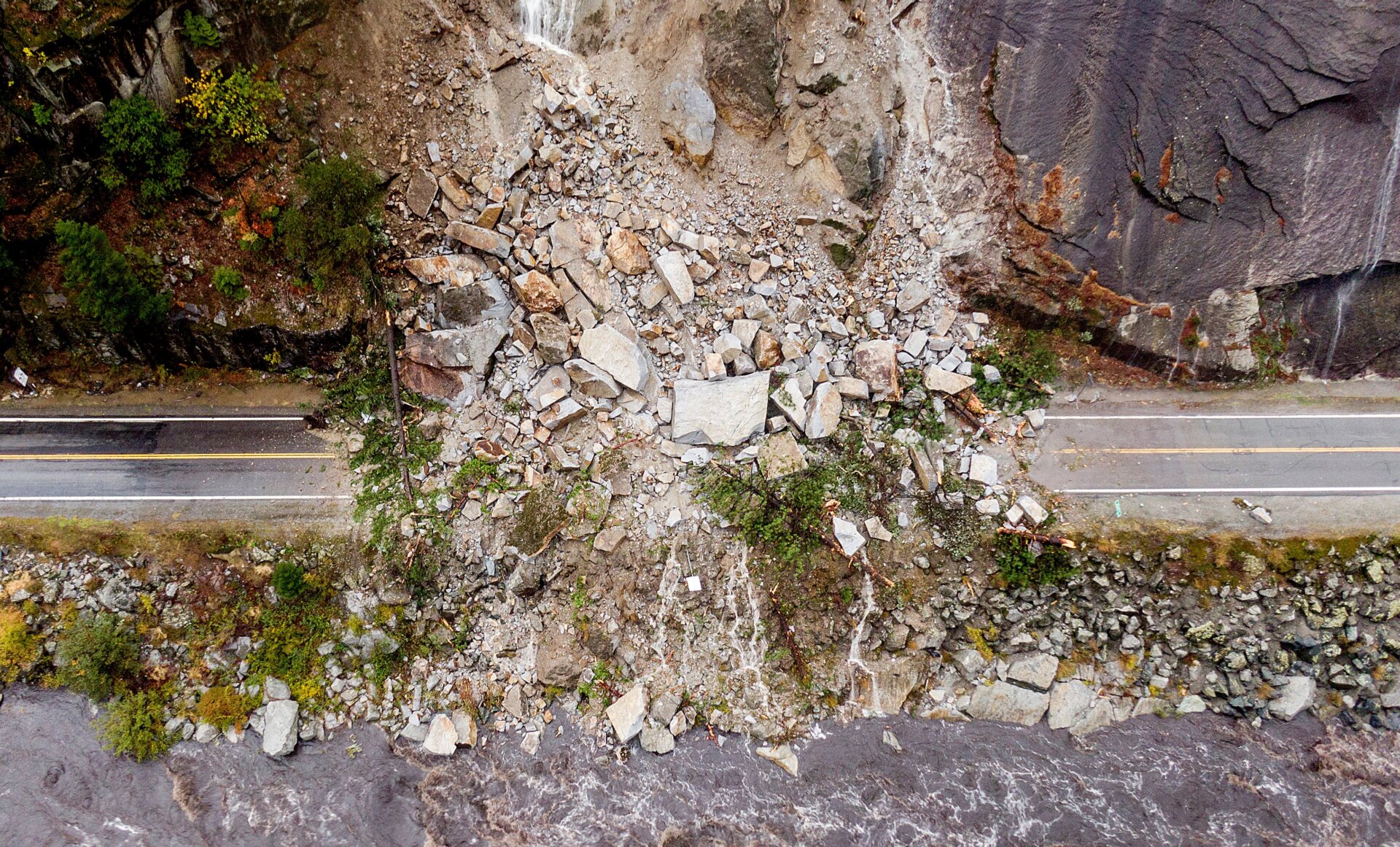 An aerial view of rocks and vegetation covering Highway 70 following a landslide in the Dixie Fire zone.