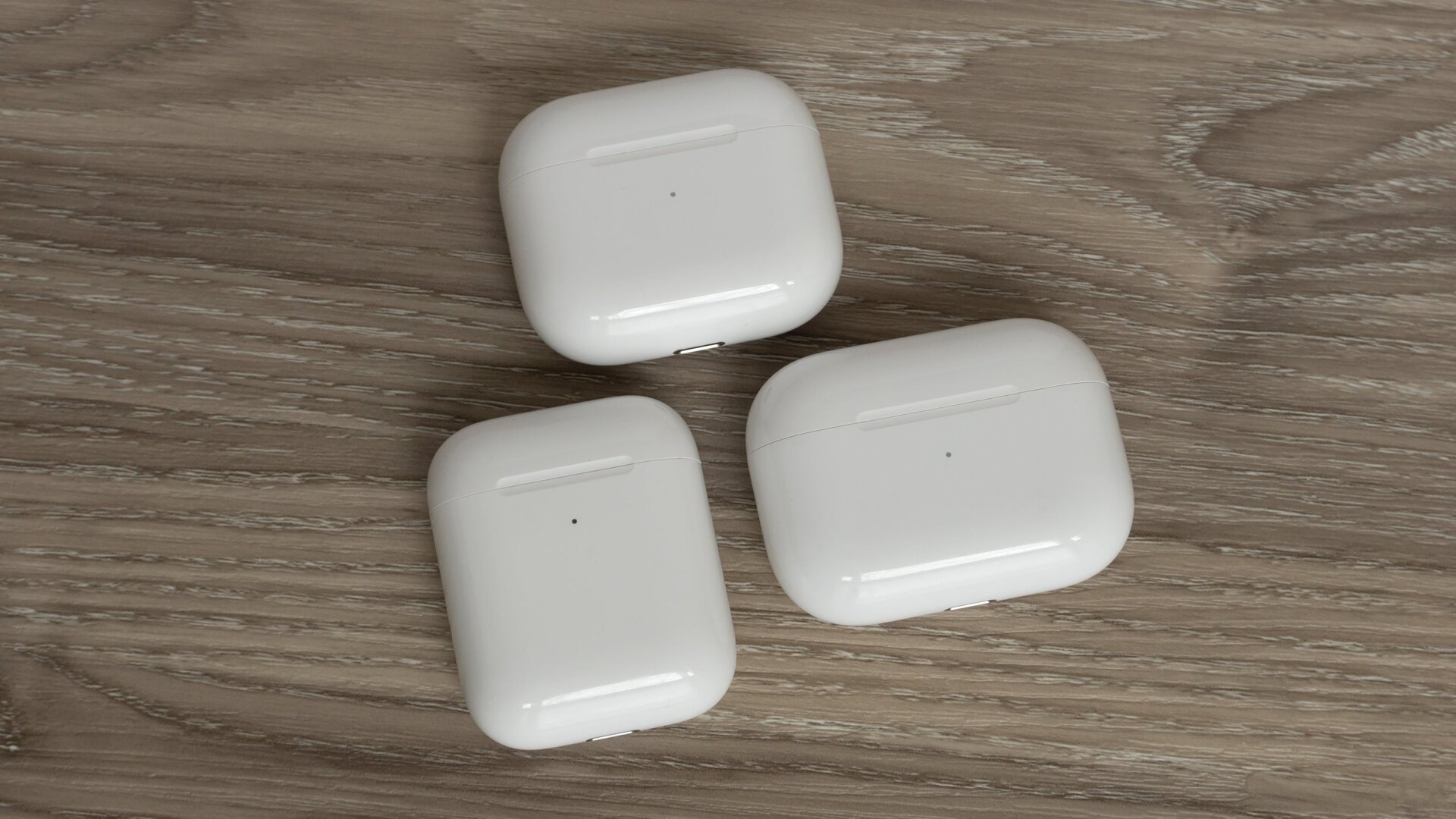 The third-gen AirPods charging case (top) compared to the second-gen charging case (bottom left) and the AirPods Pro charging case (bottom right).