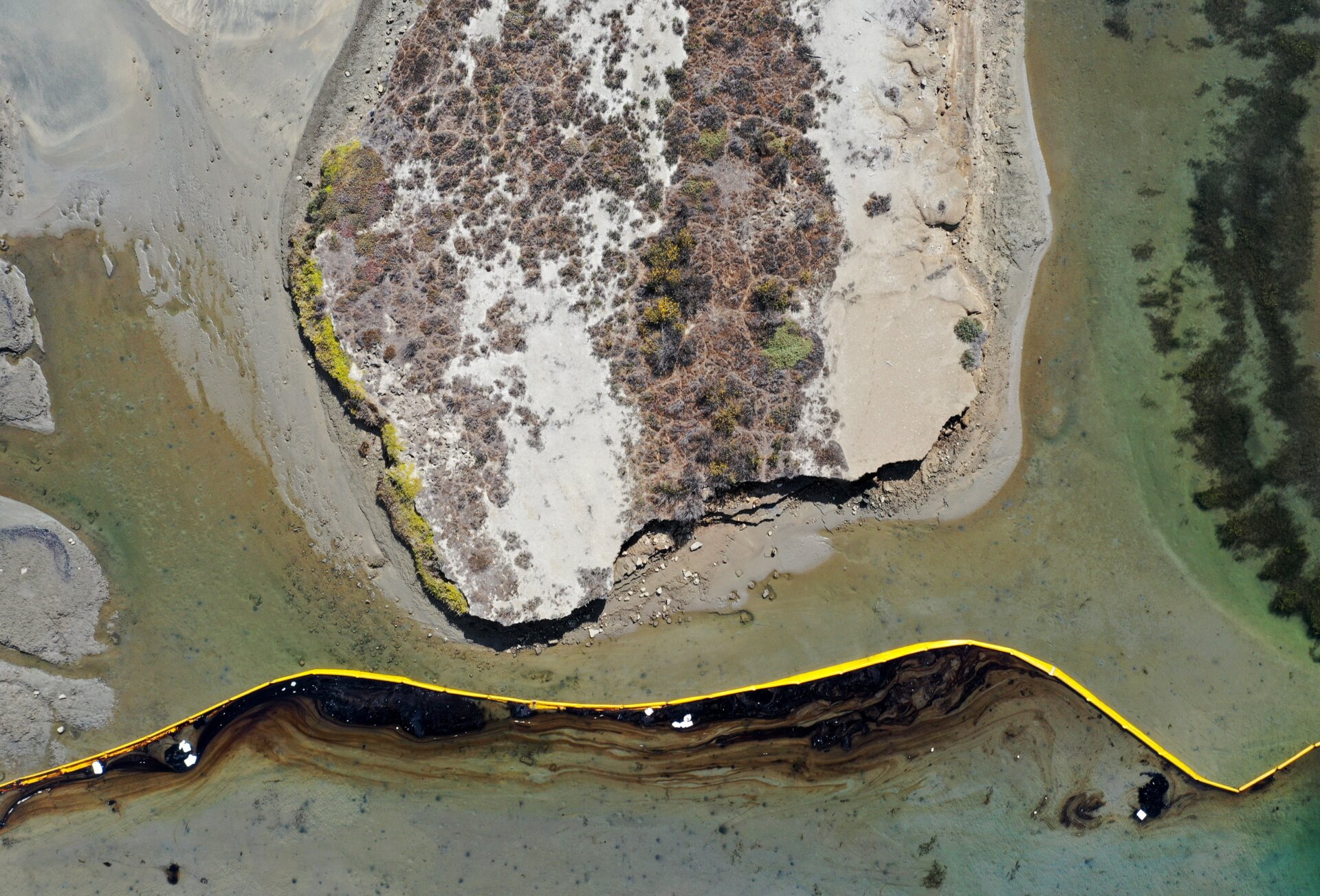 A boom contains oil-contaminated water in the area of the Talbert Marsh wetlands.