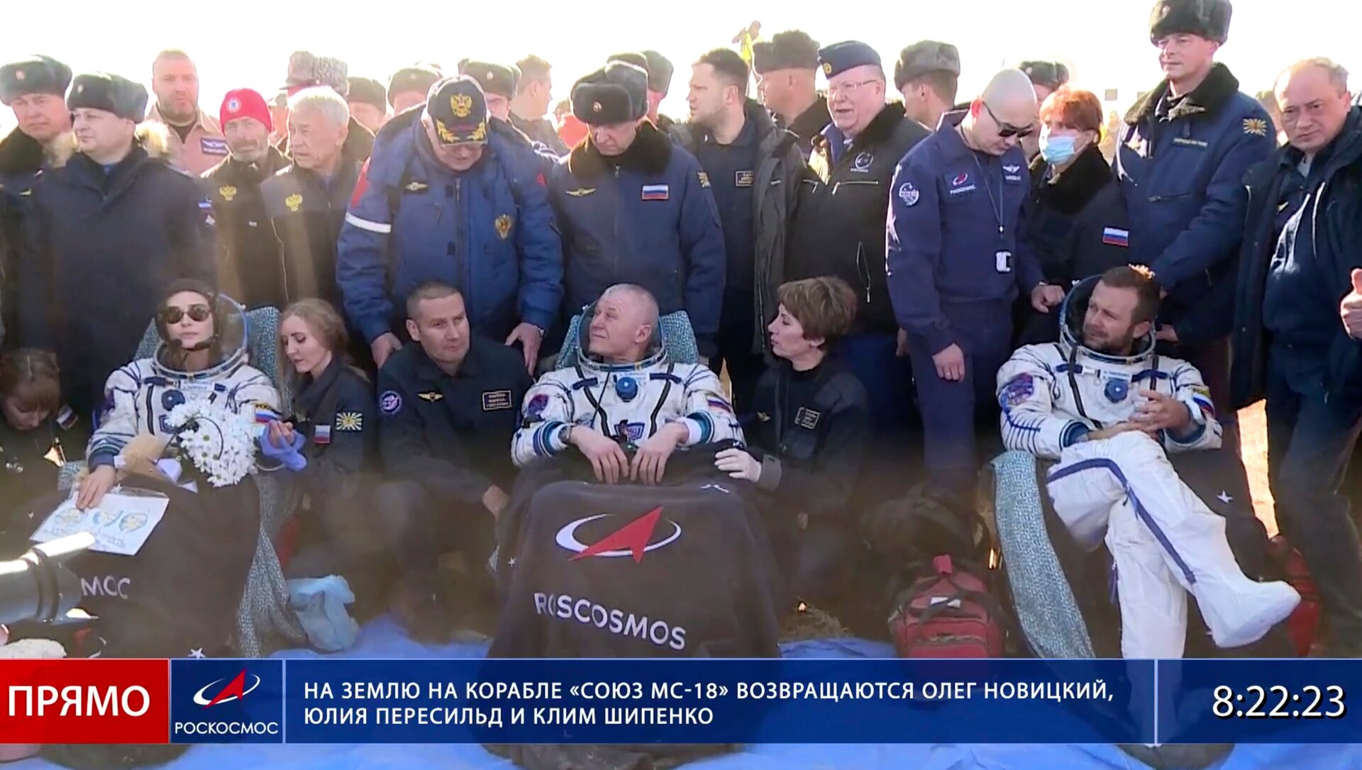Russian space agency cosmonaut Oleg Novitskiy, center, actress Yulia Peresild, left, and film director Klim Shipenko sit in chairs shortly after the landing of the Russian Soyuz MS-18 space capsule.