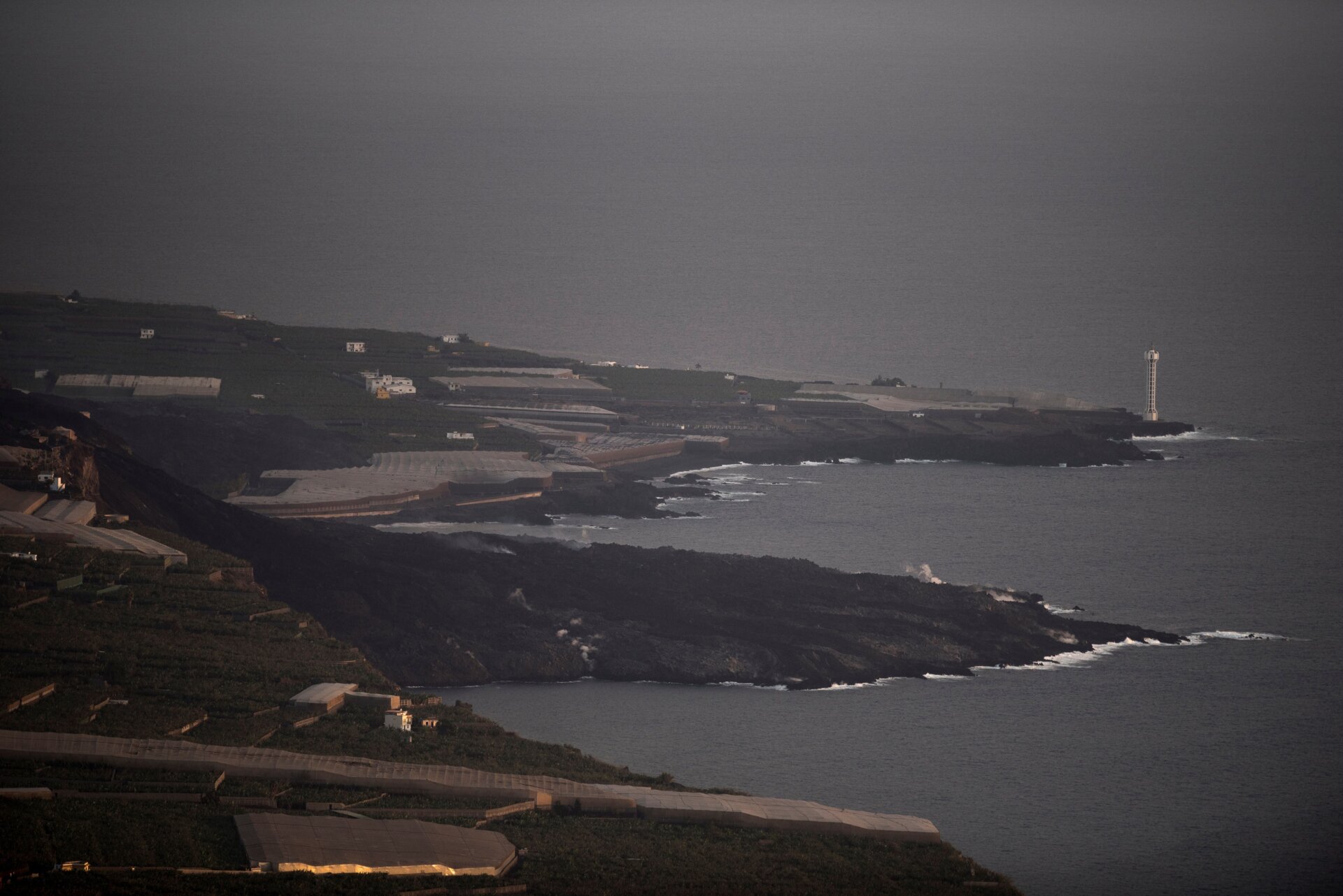 The lava flow produced by the Cumbre Vieja volcano falls into the Atlantic Ocean, as seen from Tijarafe, in the Canary Island of La Palma on October 10, 2021.