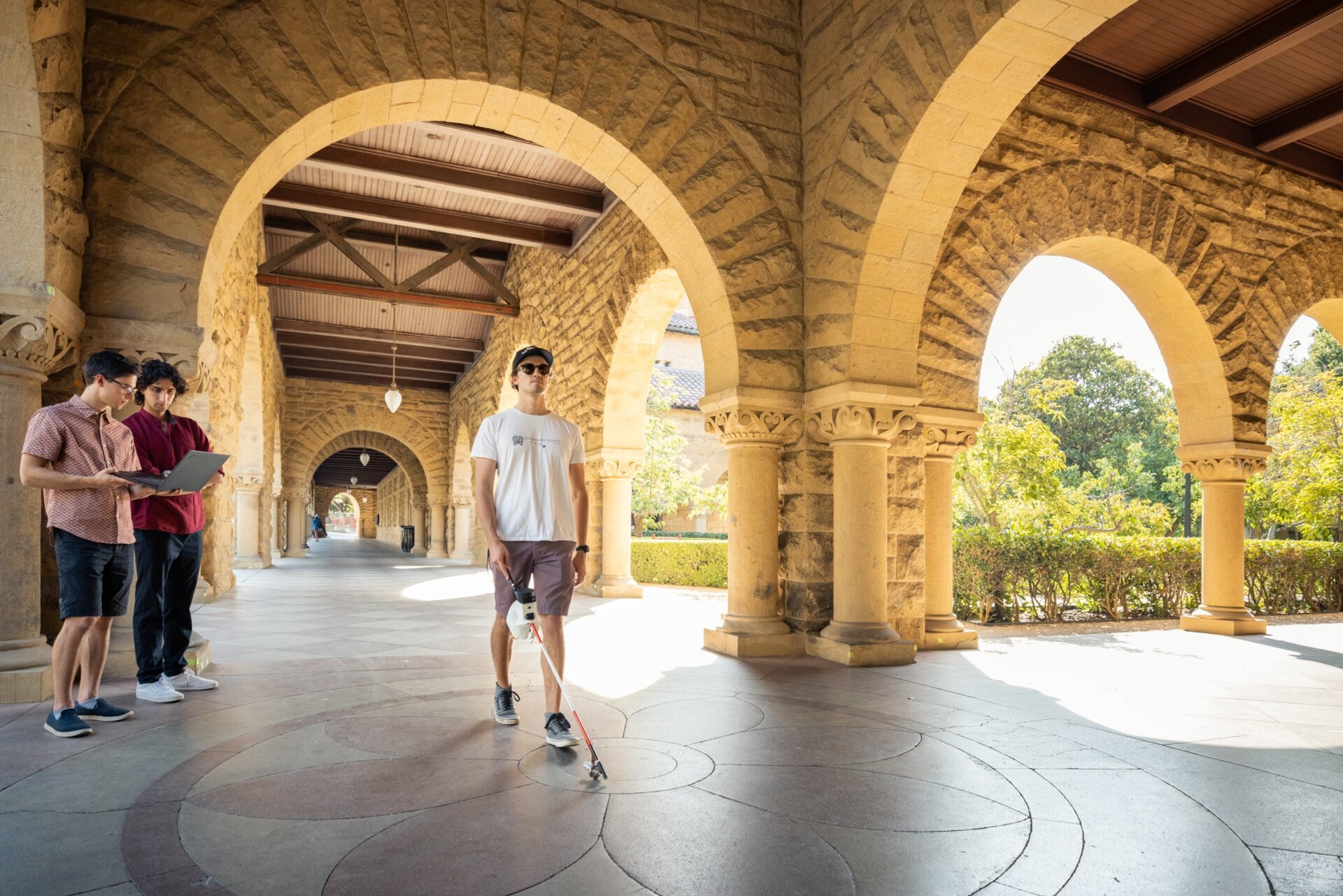 The Augmented Cane steering a participant in a hallway in front of the researchers.