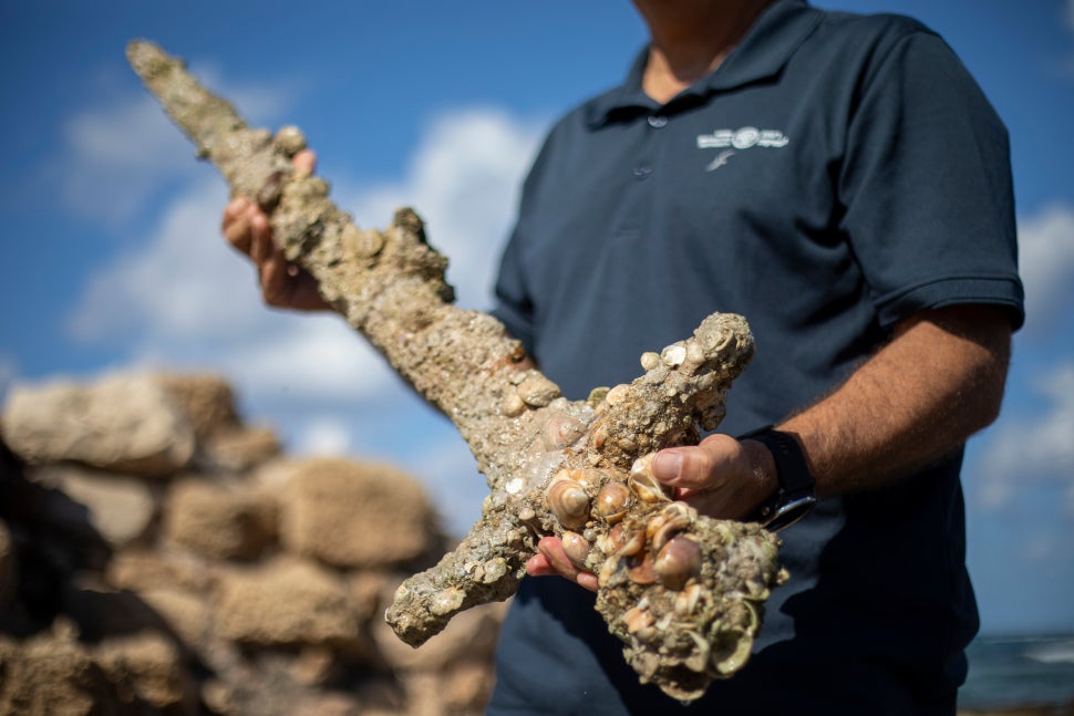 Jacob Sharvit, director of the Marine Archaeology Unit of the Israel Antiquities Authority, holding the sword. 