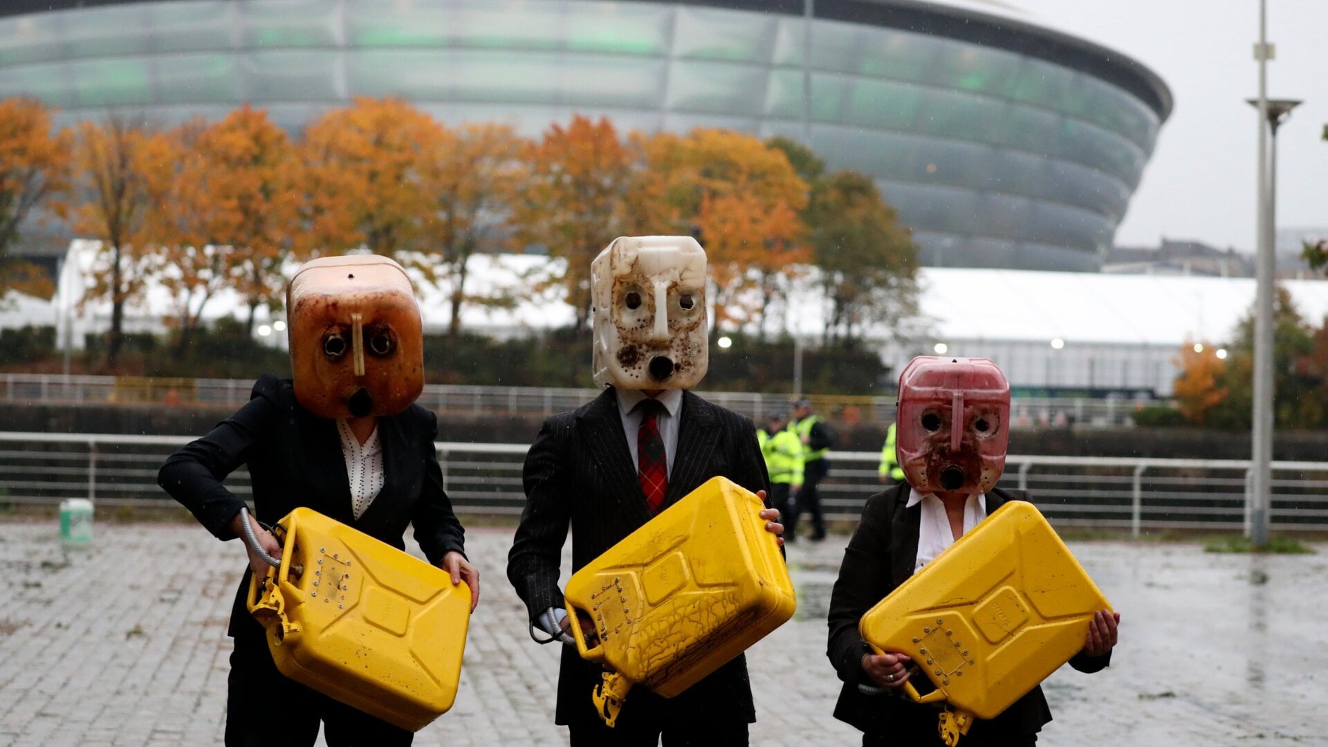 Activists hold jerrycans after spilling fake oil during their performance near the venue where the U.N. climate conference is being held in Glasgow, Scotland.