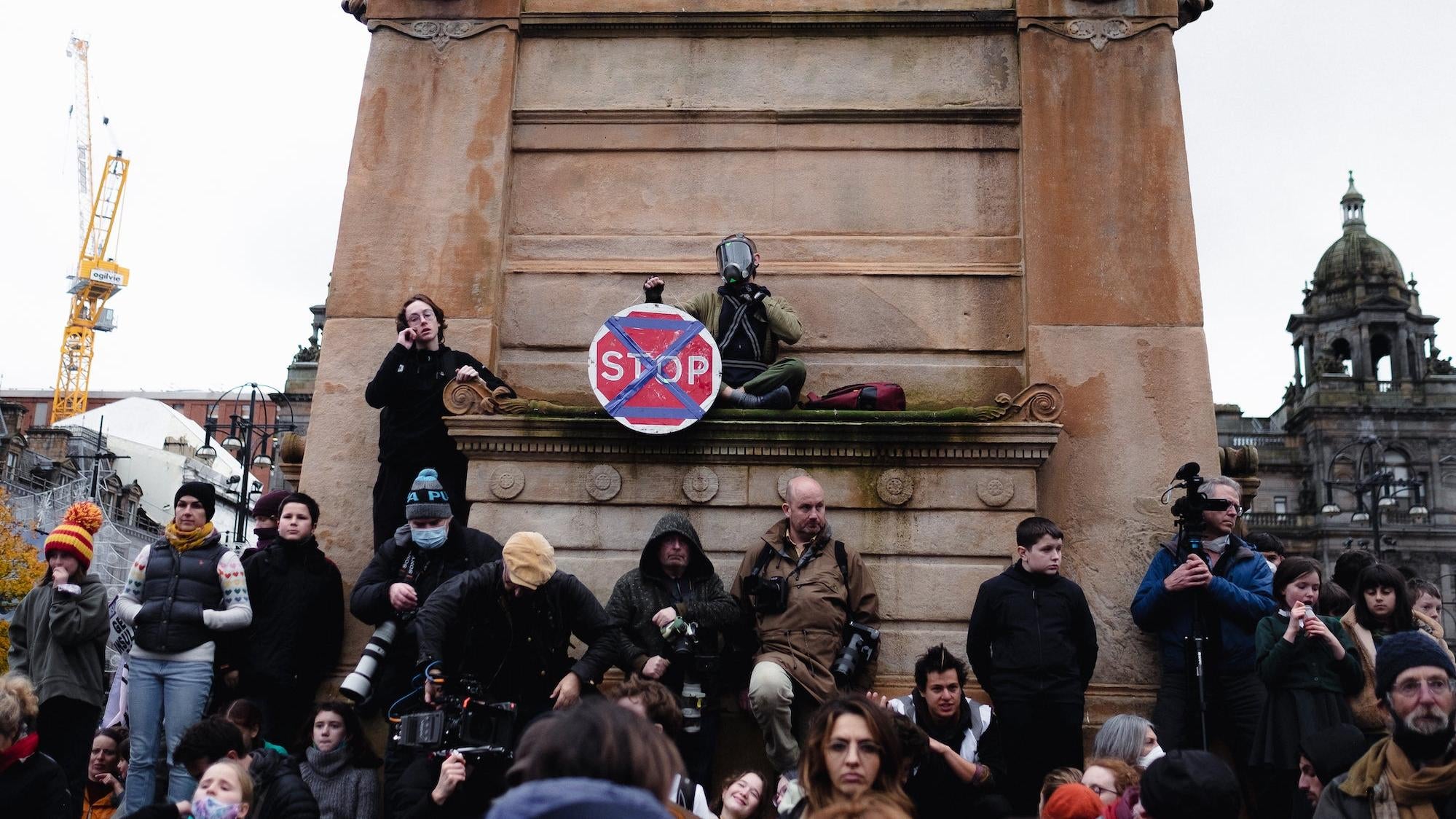 A protester displays the Extinction Rebellion symbol on a stop sign in George Square.