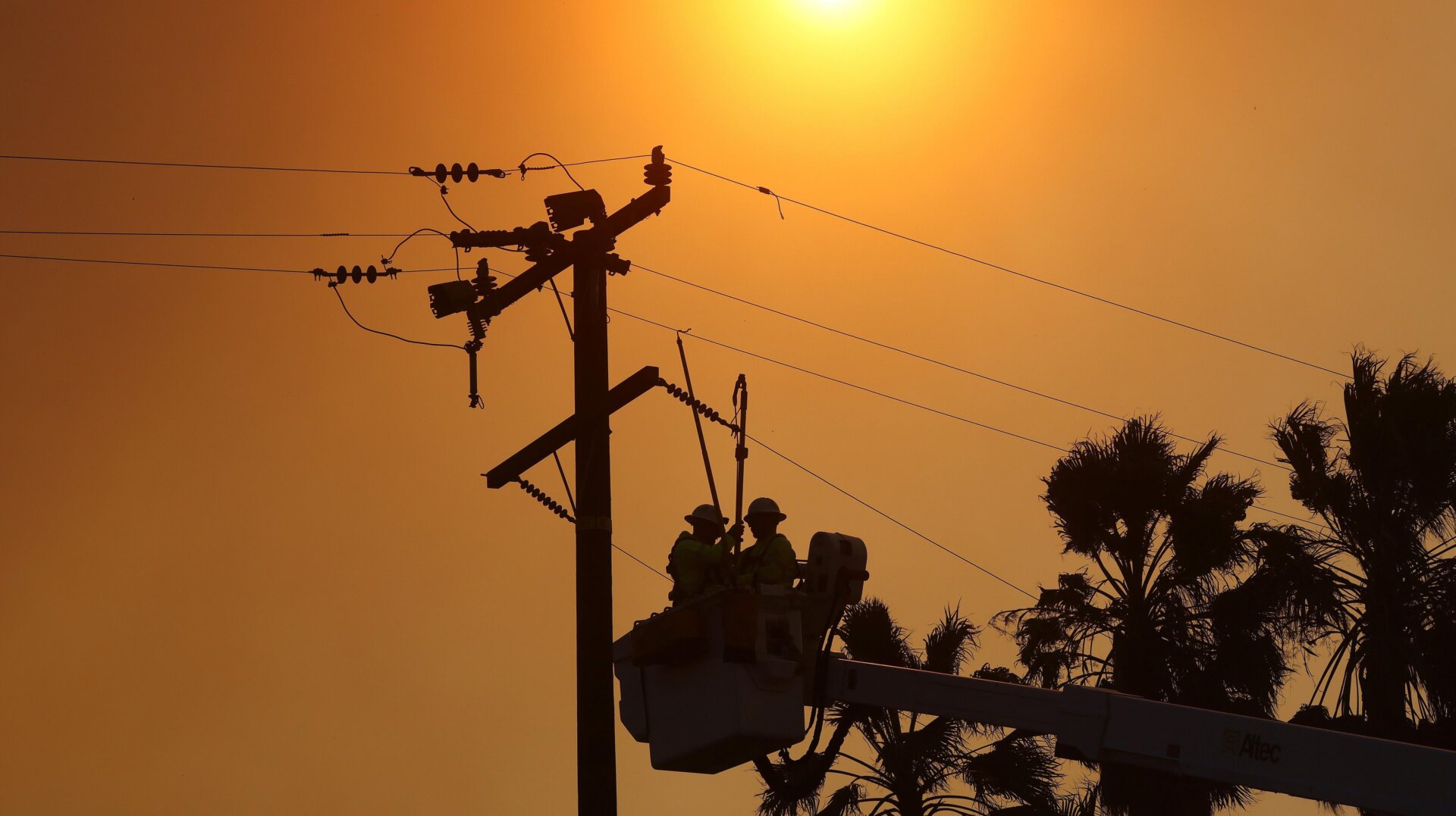 Workers repair power lines damaged during the Bond Fire in the Silverado Canyon area of Orange County on December 3, 2020 near Irvine, California. The 4,000-acre wildfire broke out along with a number of other fires in Southern California amid gusty Santa Ana winds in the region.