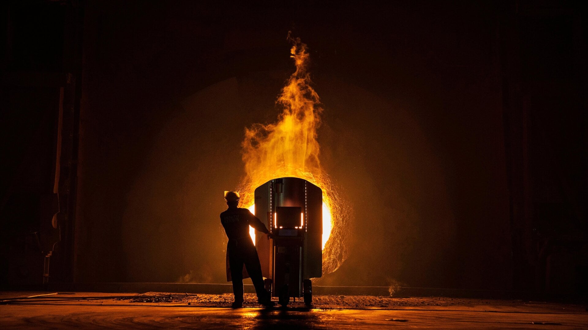 A worker takes samples to measure the quality of molten iron.