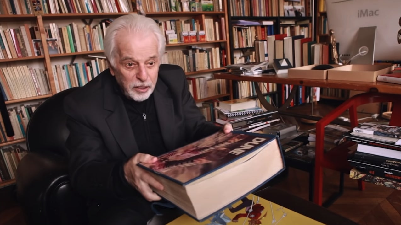 Alejandro Jodorowsky and a copy of his Dune book, one of which is going up for auction.