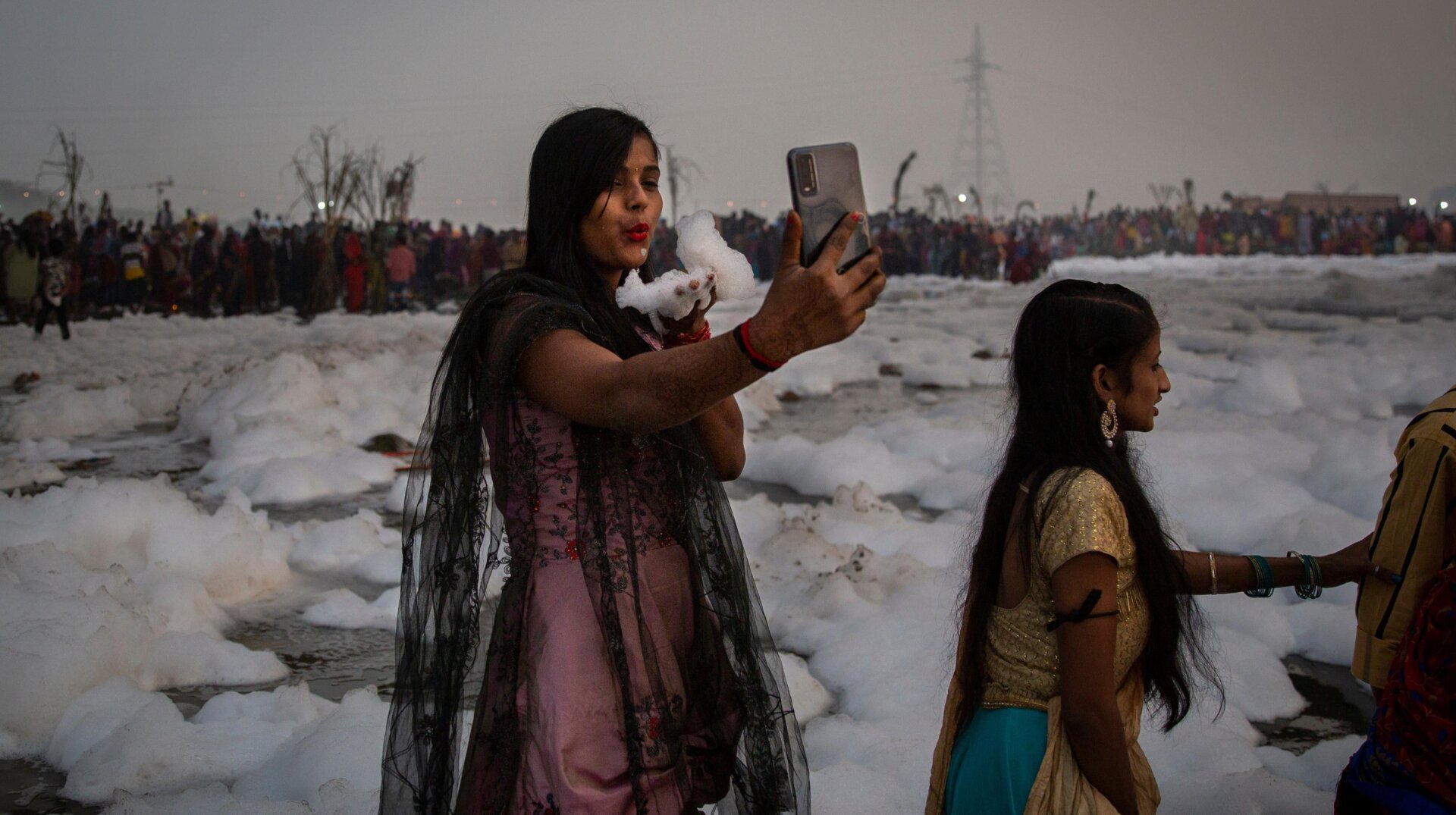 A woman takes a selfie while holding handful of chemical foam.
