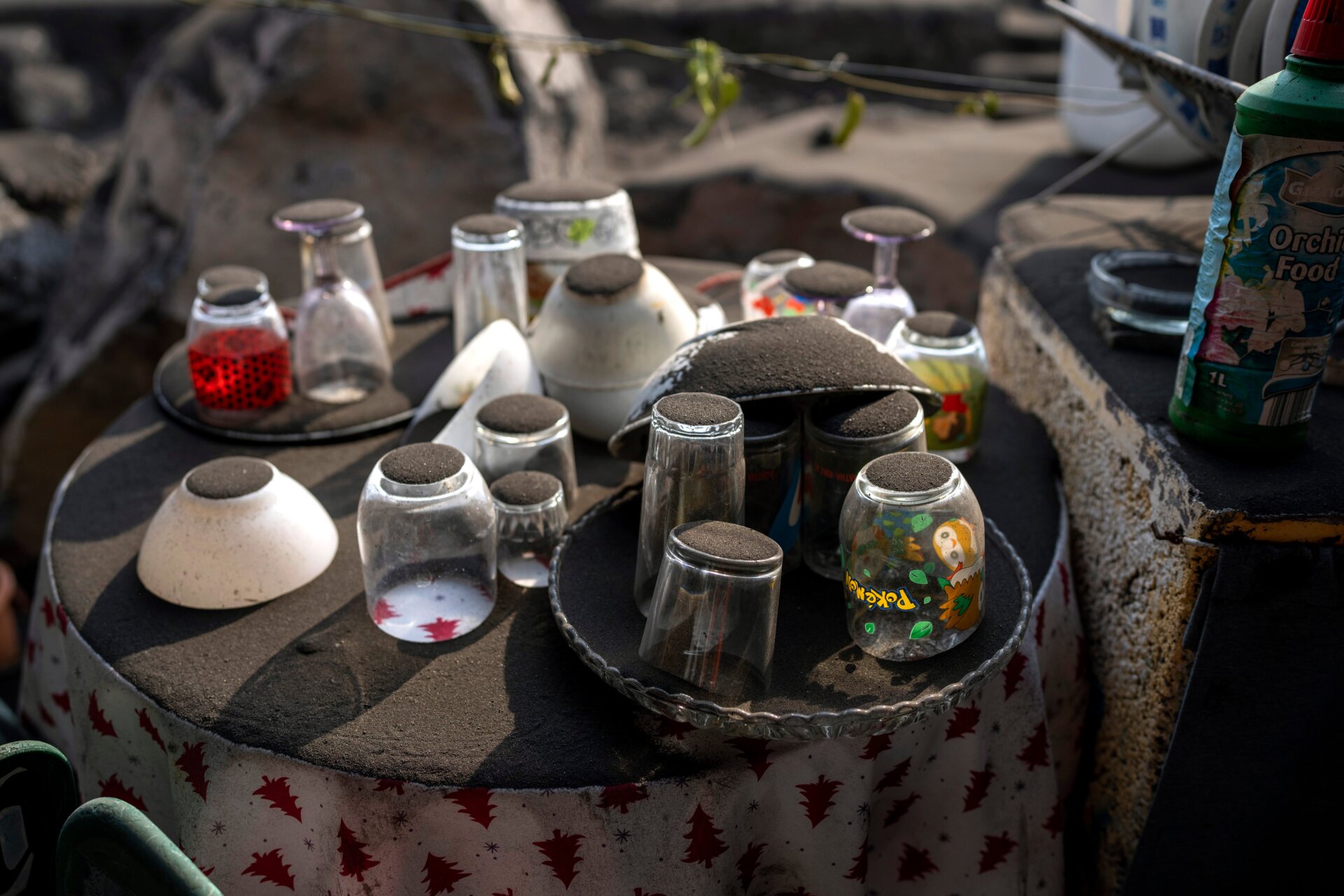 Ash from a volcano covers a crockery set left behind by residents who were evacuated from the village.