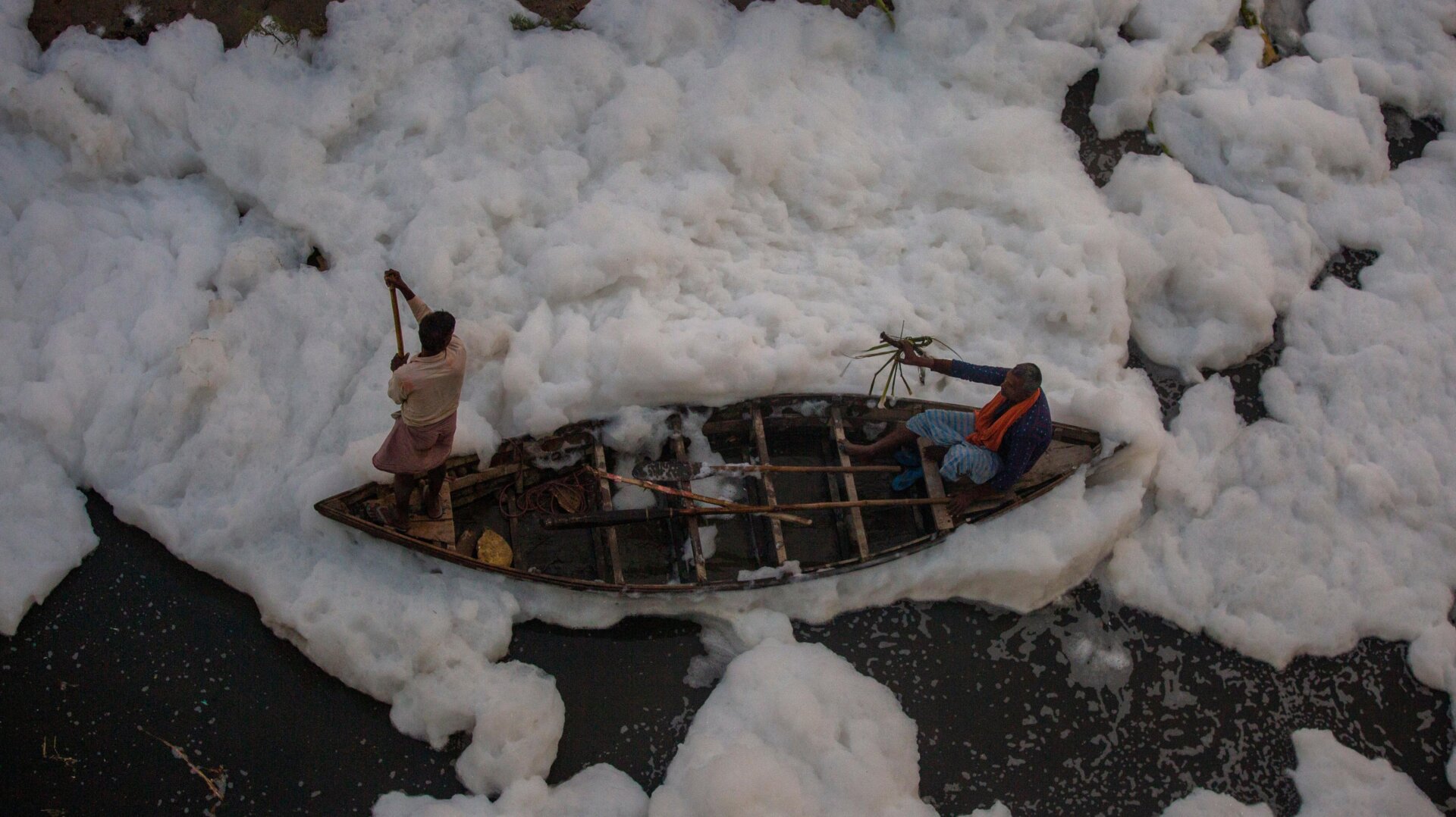 A man rows a boat in Yamuna River.