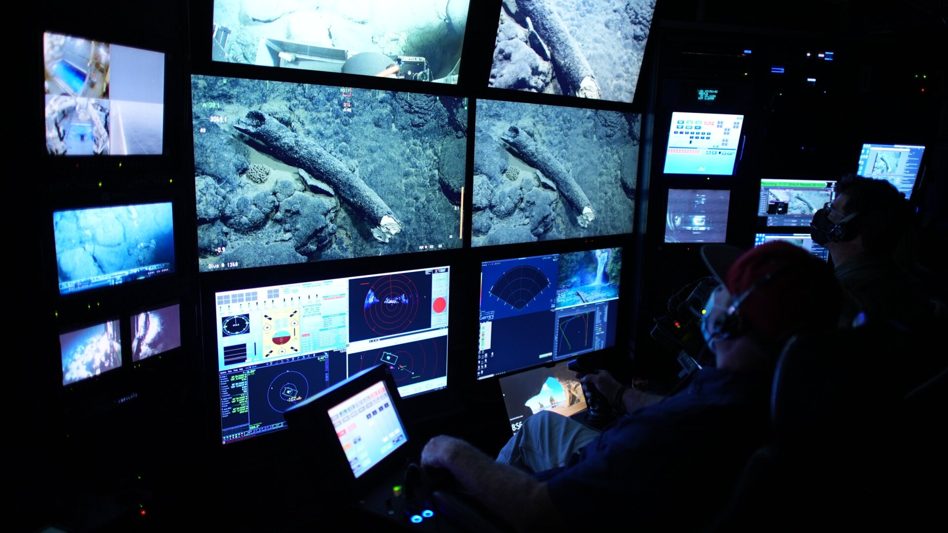 Randy Prickett (left) pilots an MBARI ROV, while scientist Steven Haddock (right) documents the mammoth tusk before the retrieval operation.