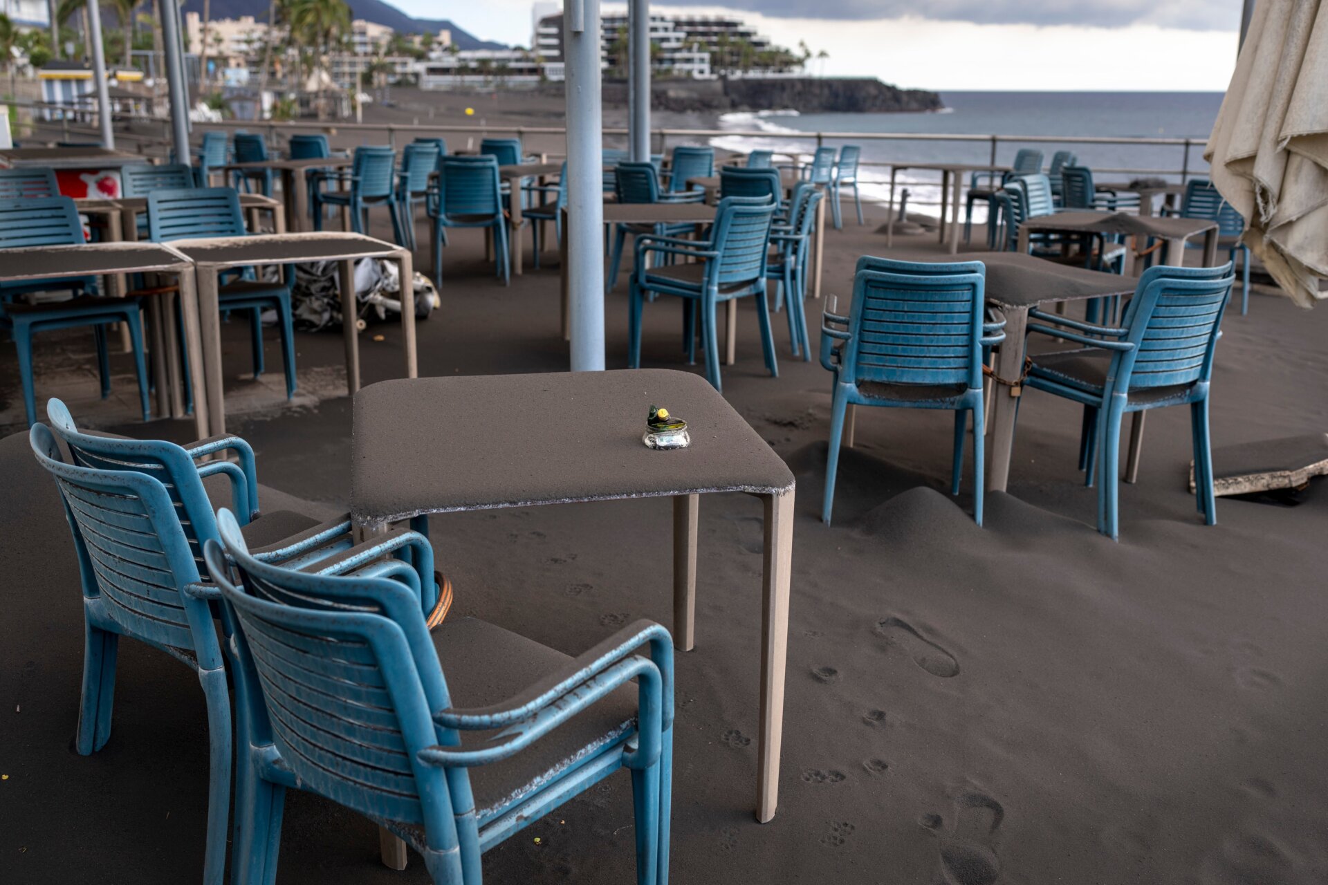 Ash covers tables and chairs on a bar terrace at the promenade of Puerto Naos village.
