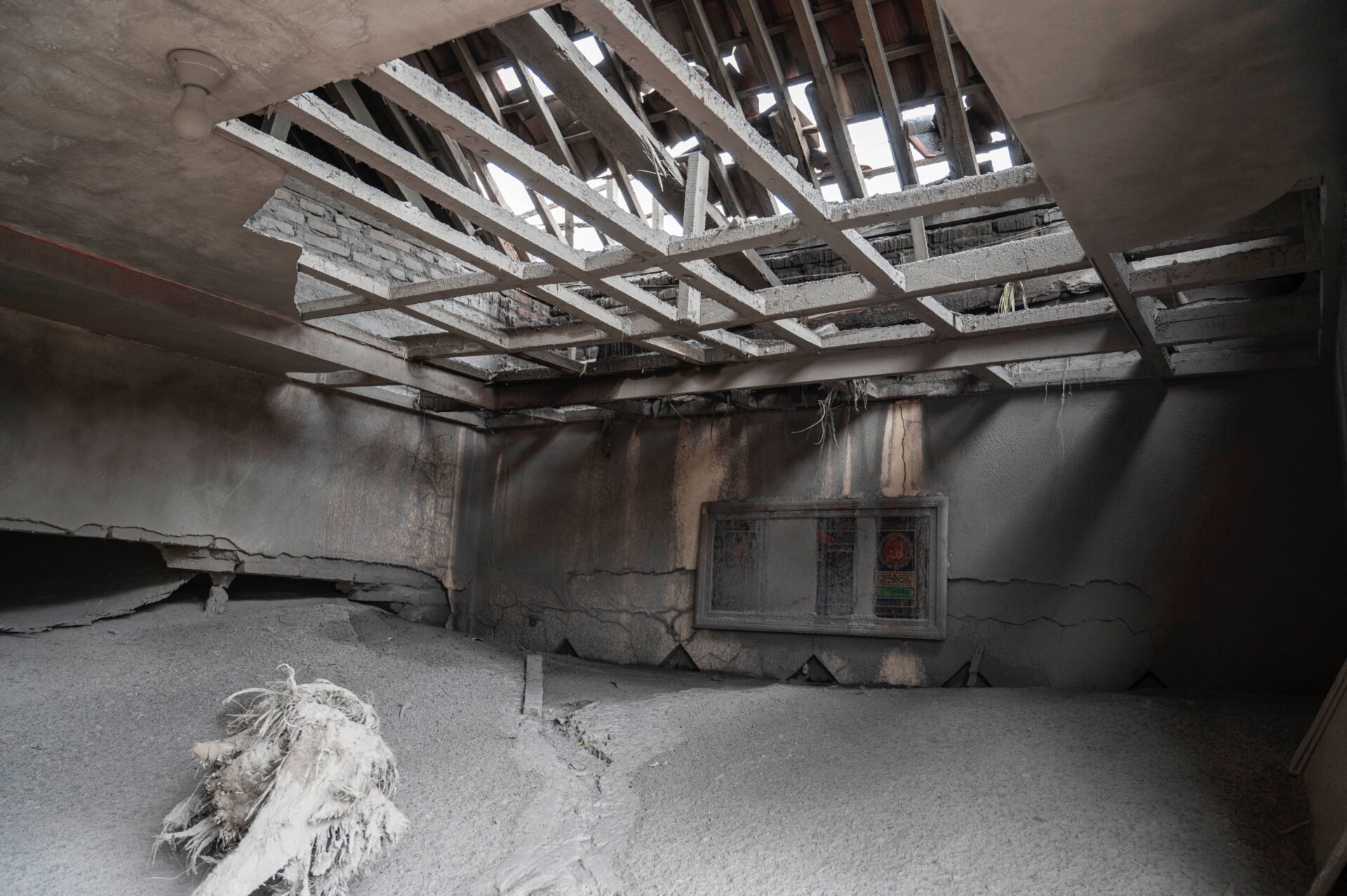 A damaged home is covered in ash at Sumber Wuluh village.