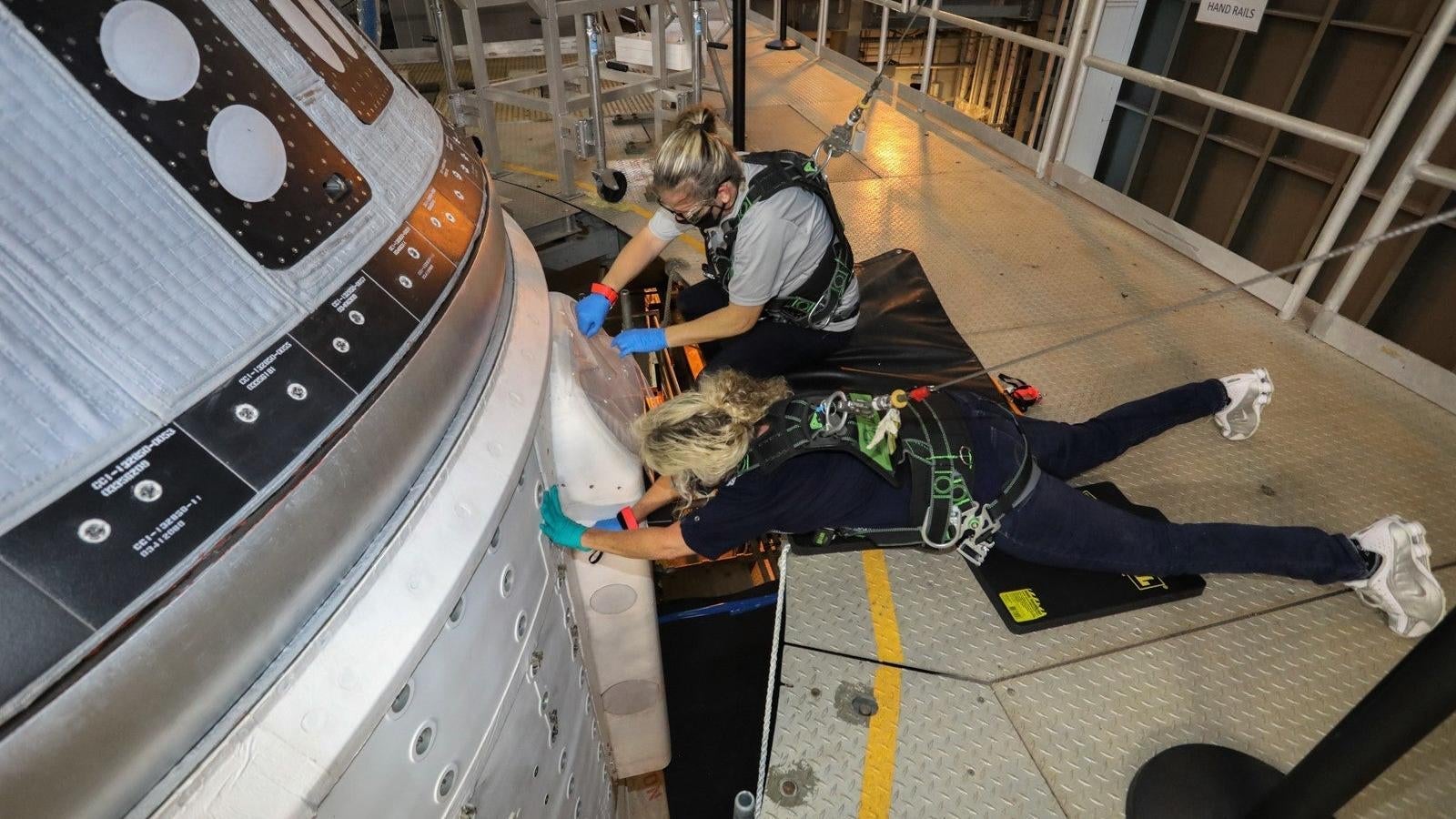 Boeing engineers attending to the faulty Starliner, parked inside the Vertical Integration Facility (VIF) at Space Launch Complex-41.