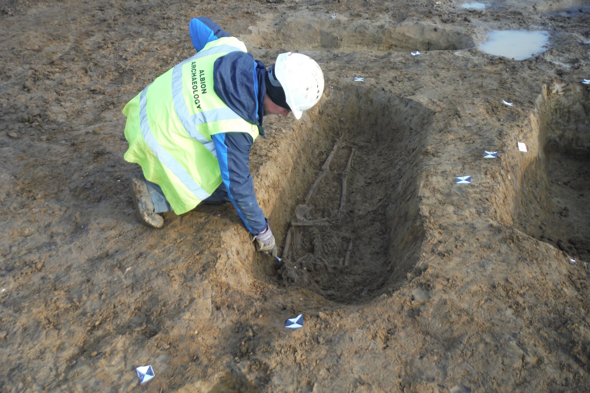 An archaeologist inspecting a grave found at the site.
