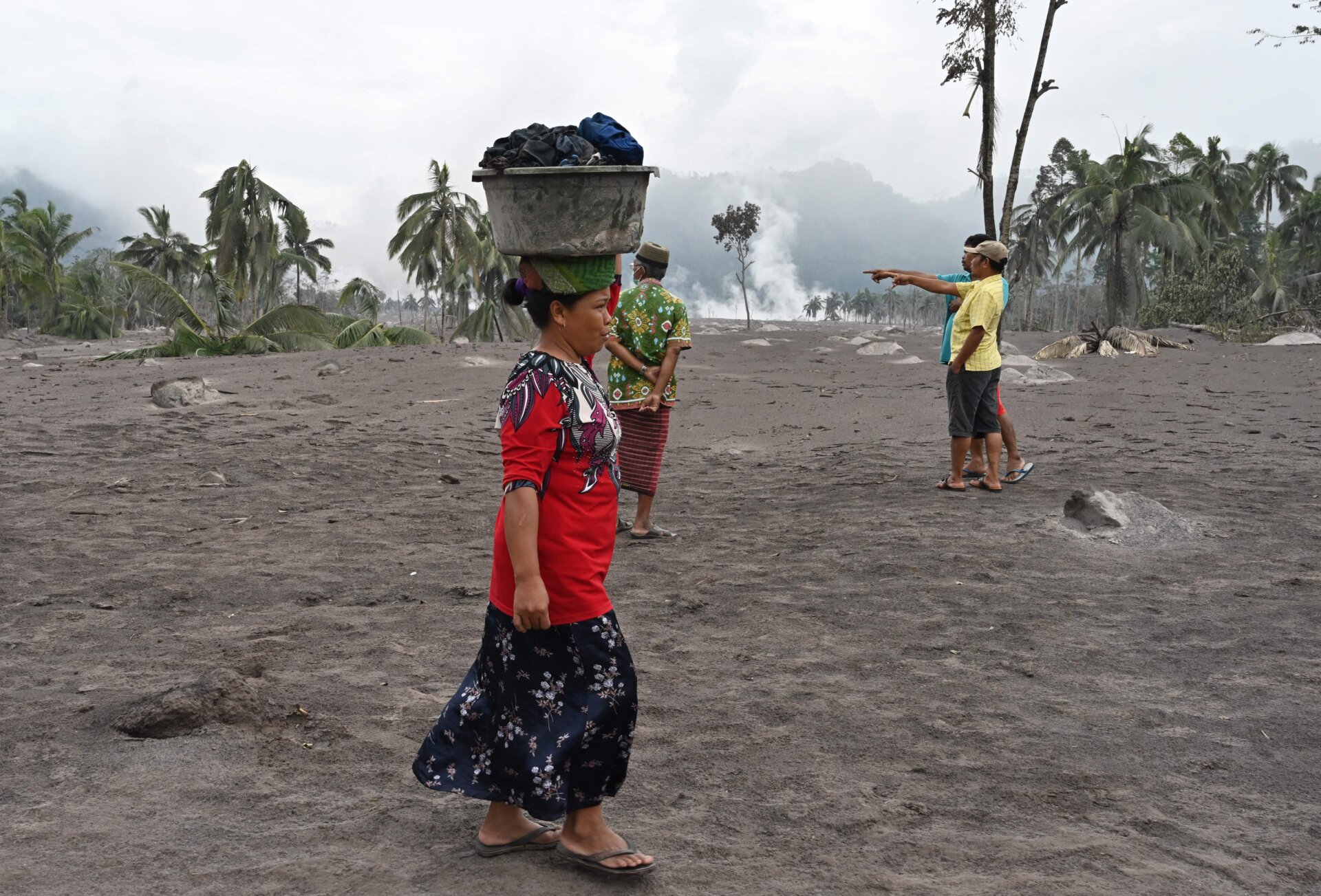 A woman salvages her belongings at the Sumberwuluh village.