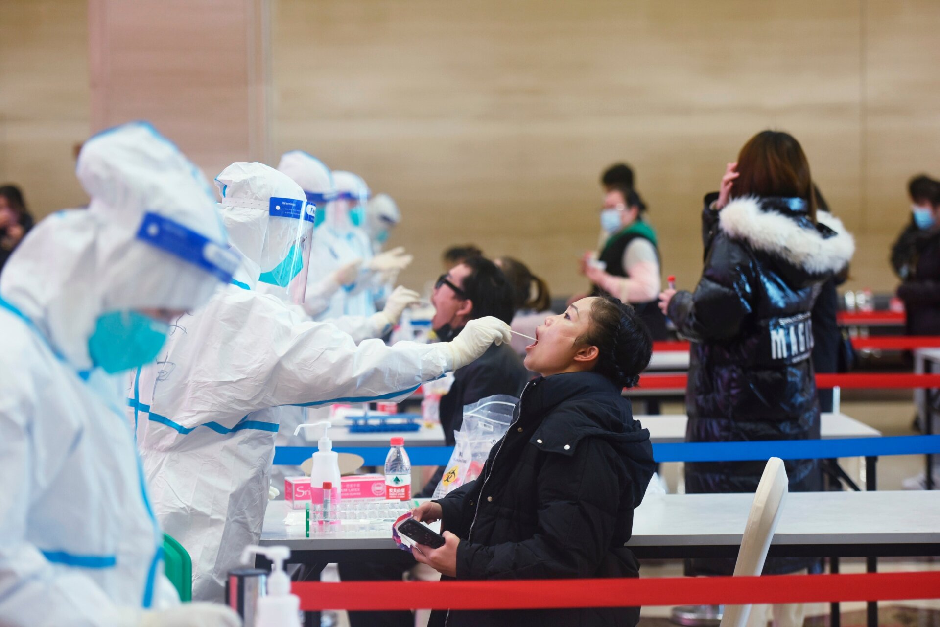A medical worker takes swab samples during a mandatory covid-19 test on workers of service industries from the Wulin business area in Hangzhou city in east China’s Zhejiang province Wednesday, Dec. 15, 2021.