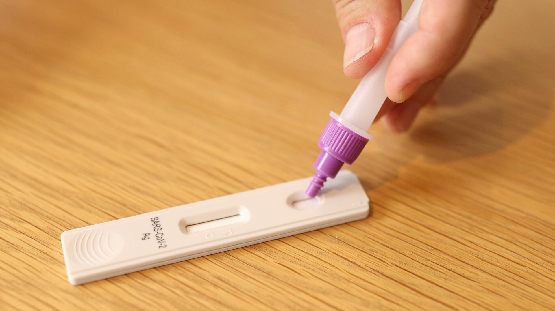 In this photo illustration a man uses a COVID-19 rapid antigen test kit at home on September 29, 2021.