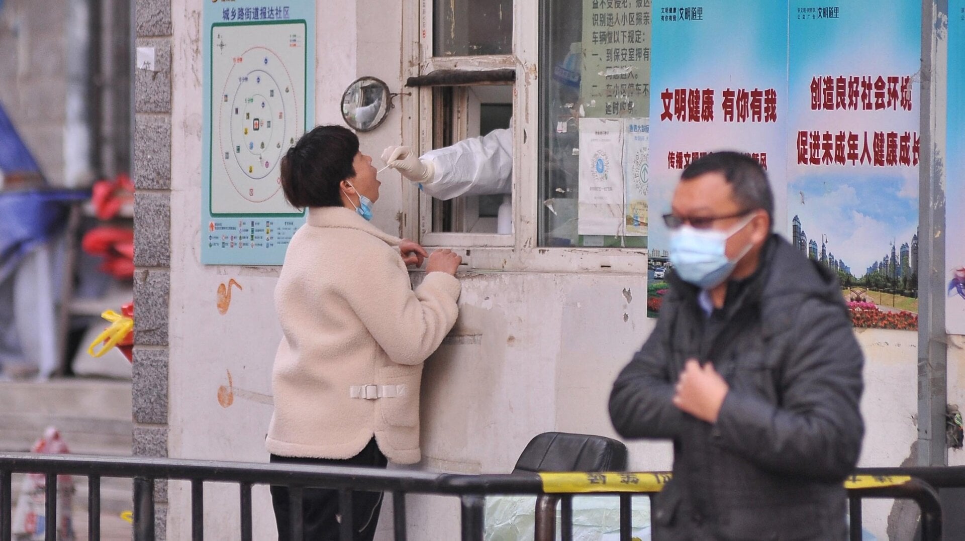 A medical worker takes a swab sample from a resident in Harbin, in China’s northern Heilongjiang province on November 3, 2021.