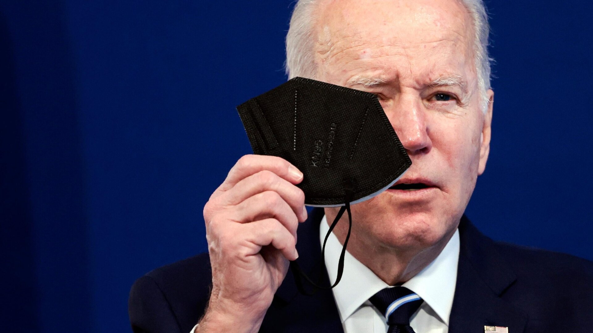 U.S. President Joe Biden holds a mask as he gives remarks in the Eisenhower Executive Office Building on January 13, 2022 in Washington, D.C.