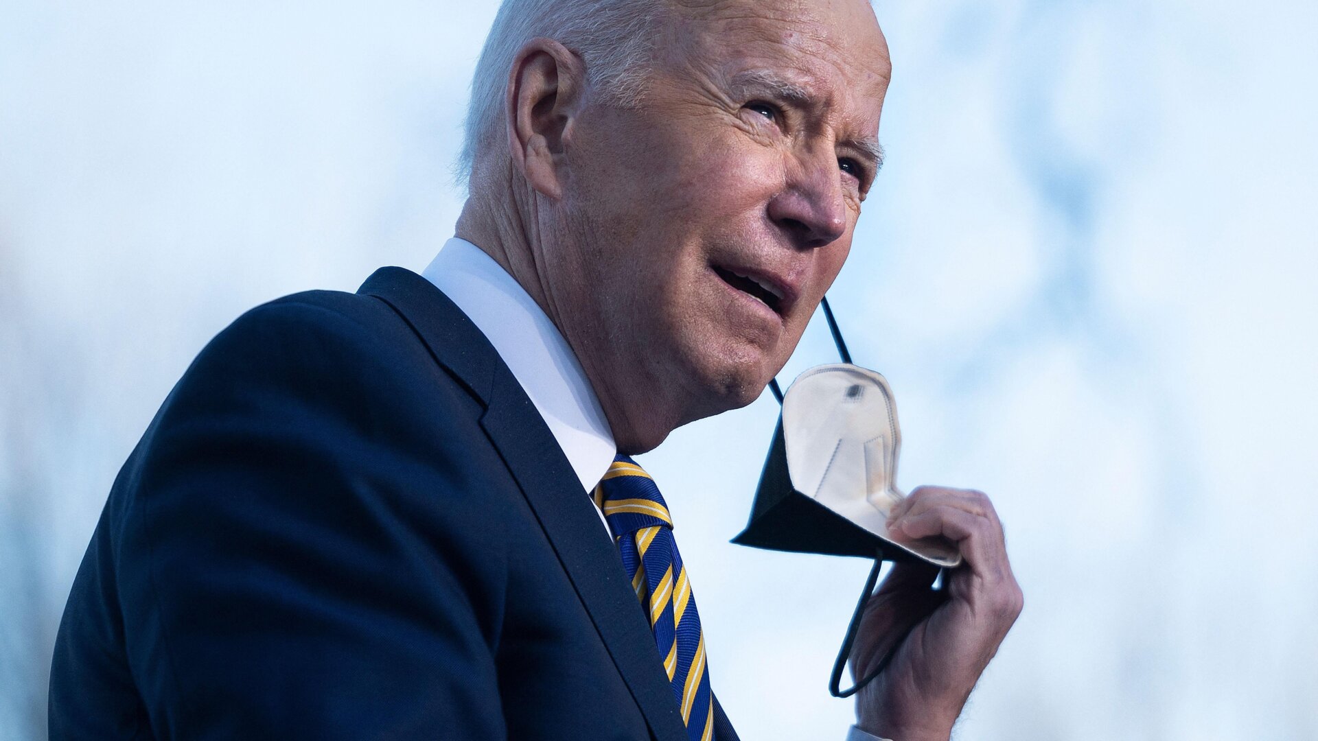 President Joe Biden removes a high-quality mask before speaking at the Atlanta University Center Consortium in Atlanta, Georgia on January 11, 2022.