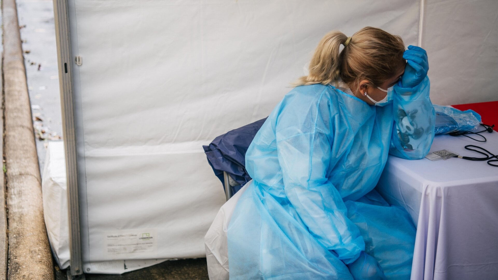 A medical assistant rests while waiting for patients at an abandoned Dave & Buster’s that’s been converted to a large-scale covid-19 testing facility on January 8, 2022 in Houston, Texas.