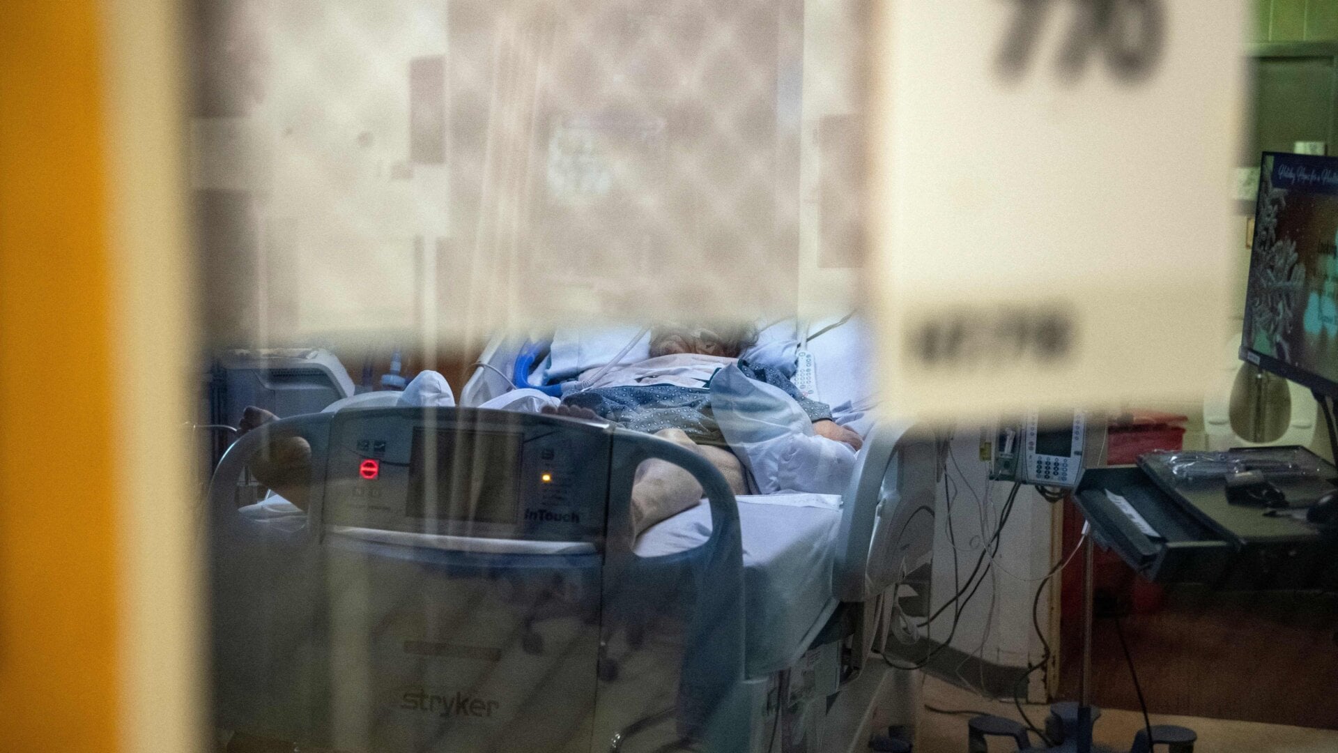 A patient with covid-19 sits in bed in a negative pressure room in the ICU ward at UMass Memorial Medical Center in Worcester, Massachusetts on January 4, 2022.