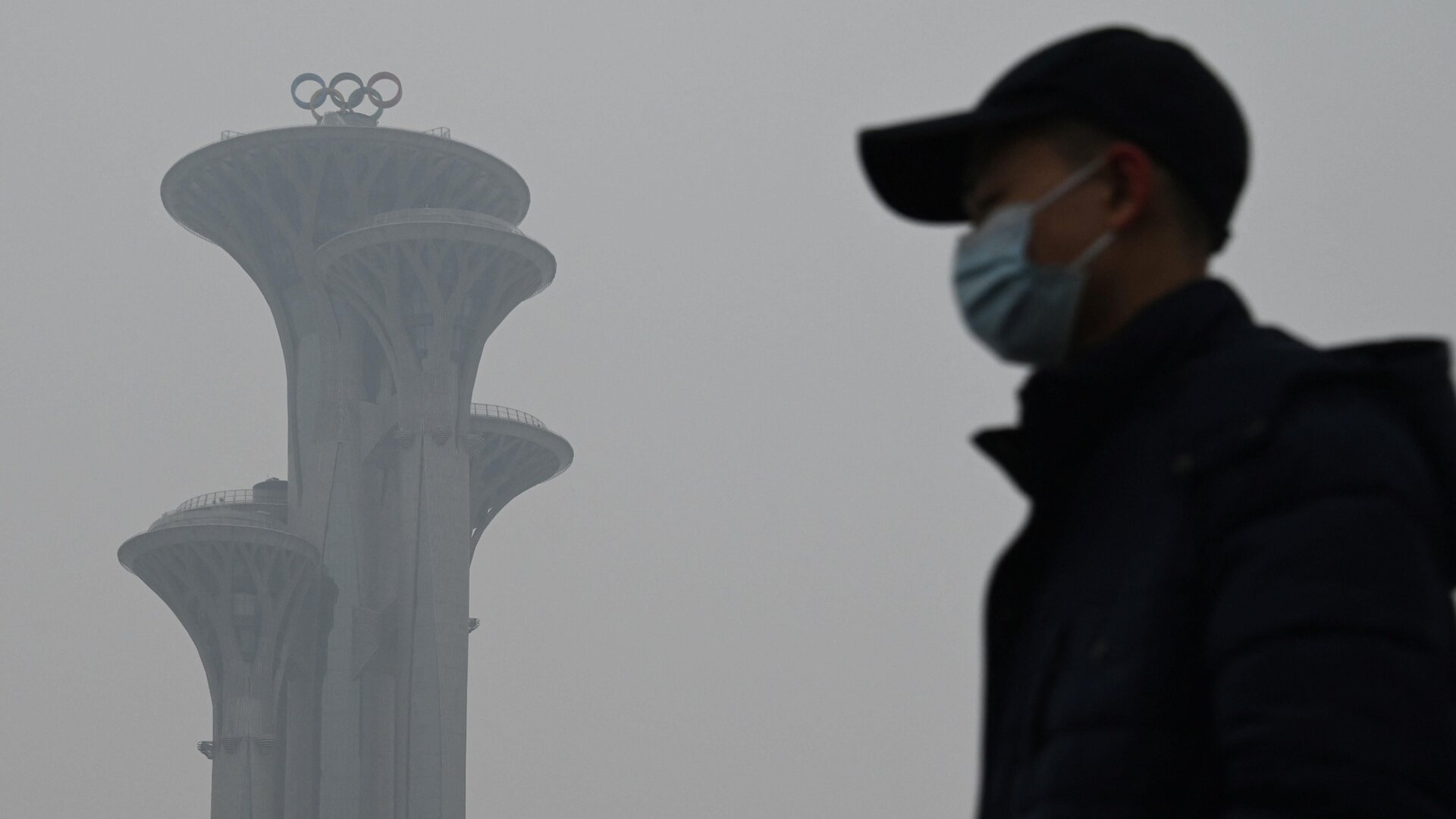 A man walks in the Olympic Park during a smoggy day in Beijing on January 24, 2022.