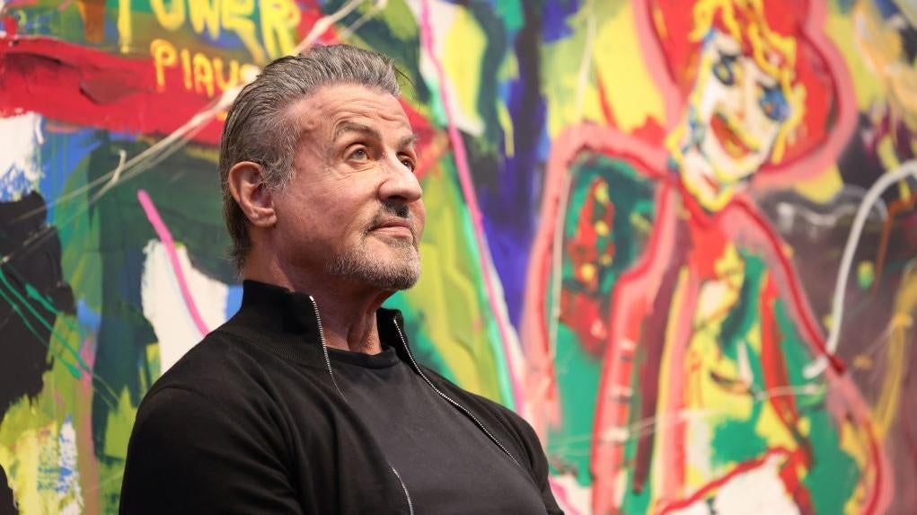 Sylvester Stallone wonders why there are no official images from his new movie, Samaritan, while at a retrospective of his artwork in Germany.