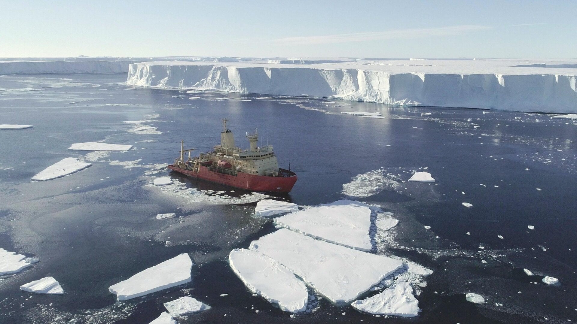 The R/V Nathaniel B. Palmer in front of the icy cliffs of Thwaites Glacier. Fragments of sea ice sit around the boat.