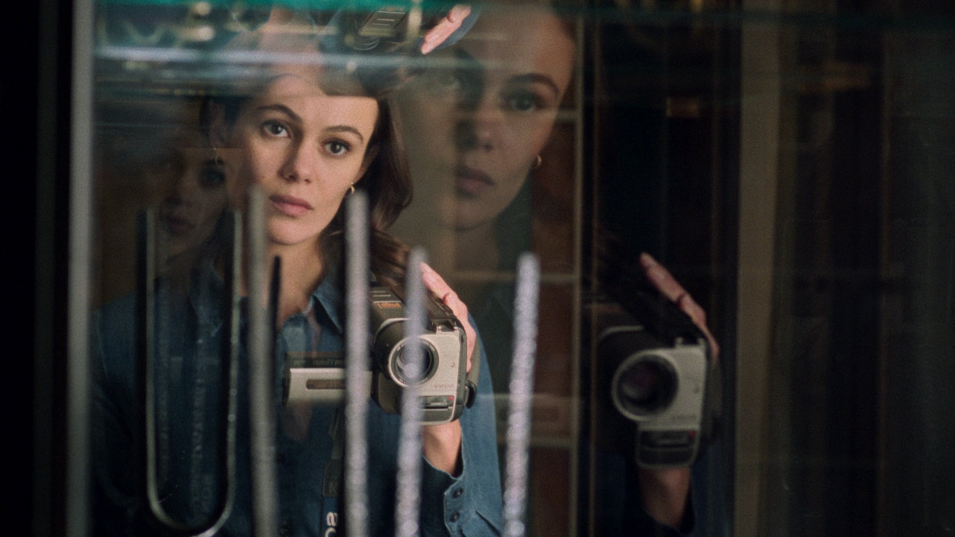 Dina Shihabi as Melody Pendras, holding her ever-present camera, in Archive 81.