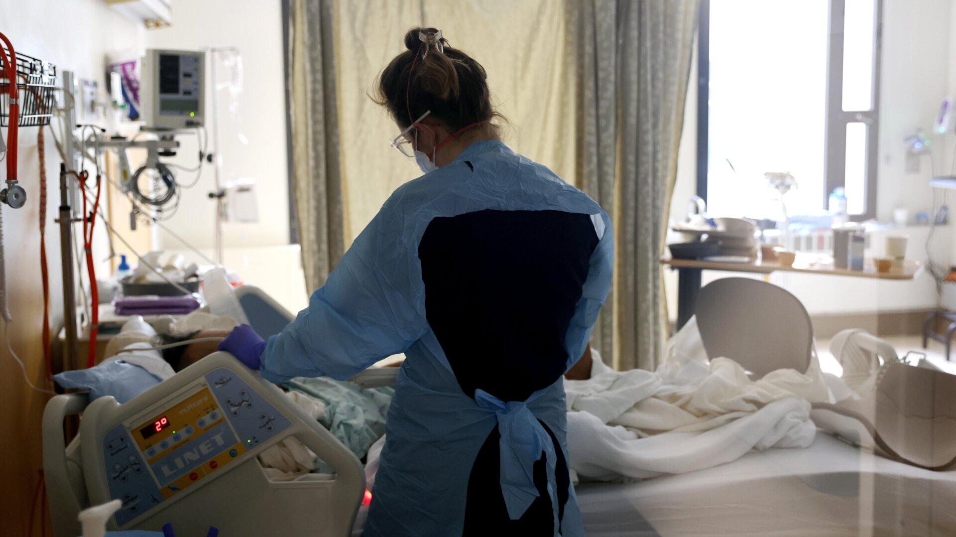 Nurse Elisa Gilbert checks on a patient in the acute care covid-19 unit at the Harborview Medical Center on January 21, 2022 in Seattle, Washington.