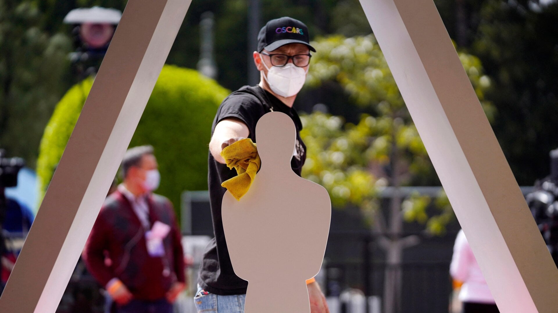 Academy Awards crew member Mike Morrisroe cleans an Oscar statue design on the red carpet at Union Station, for last year’s Academy Awards on April 24, 2021, in Los Angeles.