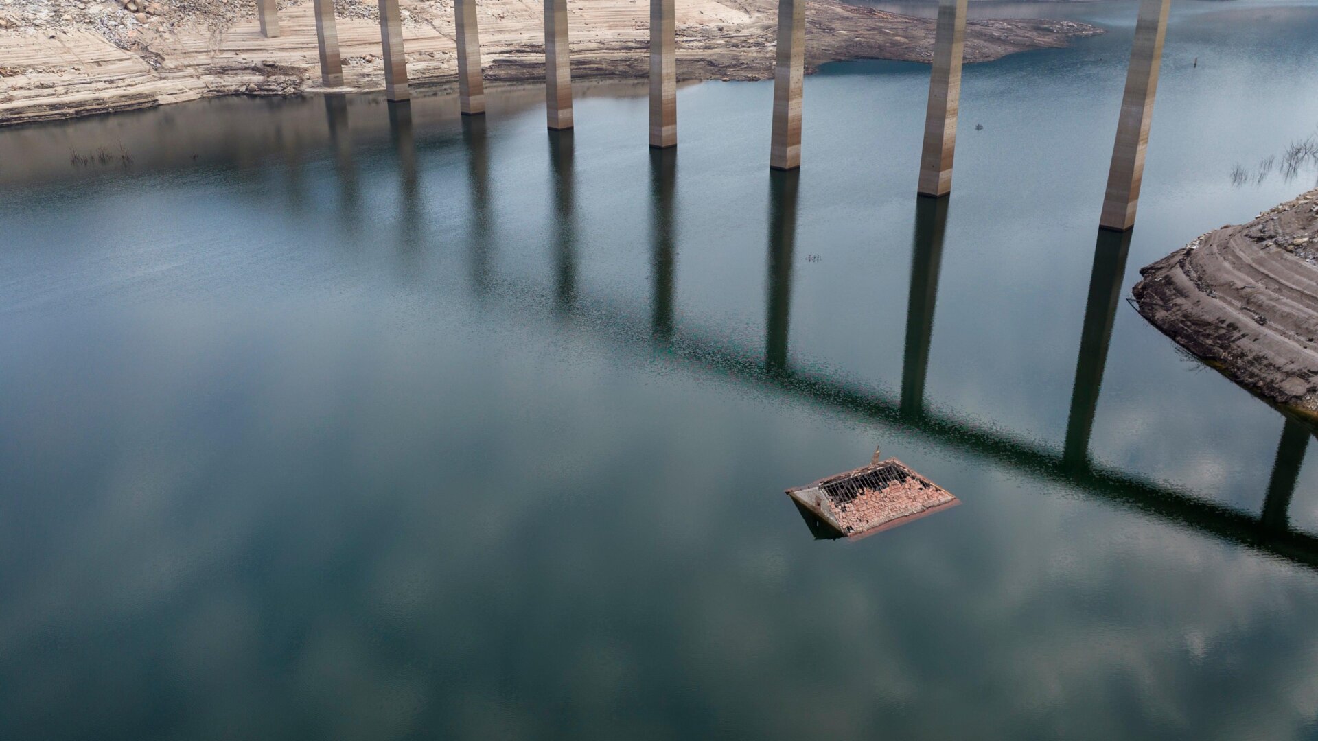 The roof of an old house, submerged three decades ago when a hydropower dam flooded the valley. It has reappeared due to drought at the Lindoso reservoir.