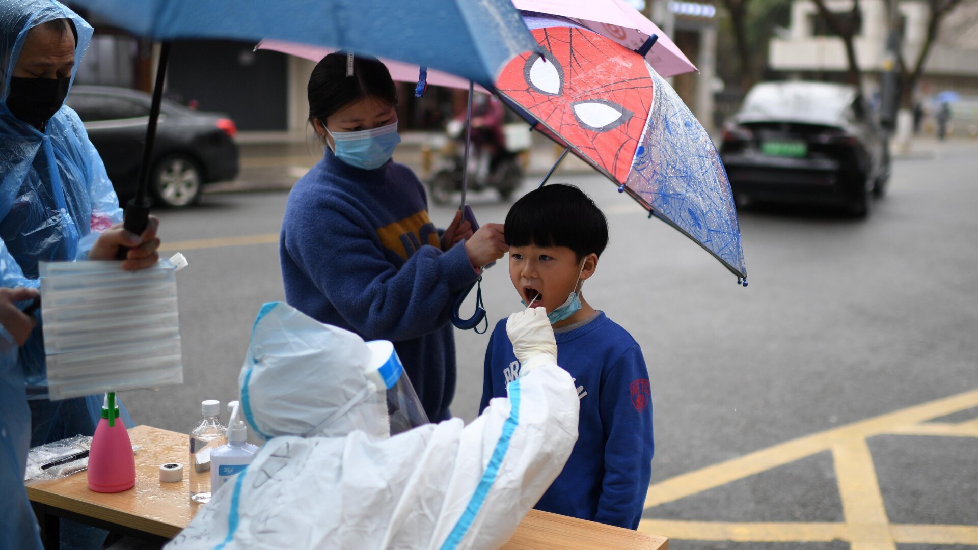 A medical worker takes swab samples on a resident for the mandatory covid-19 test in Wuhan in central China’s Hubei province on March 6, 2022.