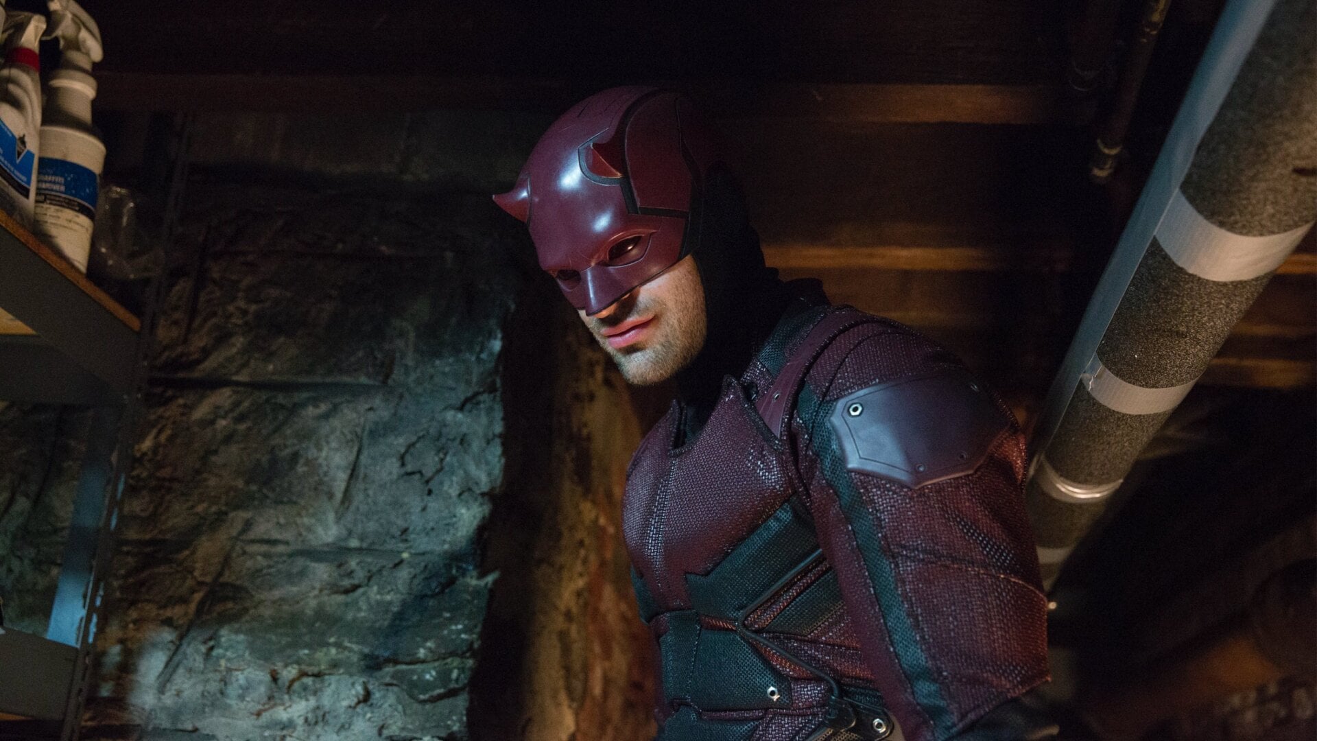 Daredevil grins grimly in his maroon and black armor.