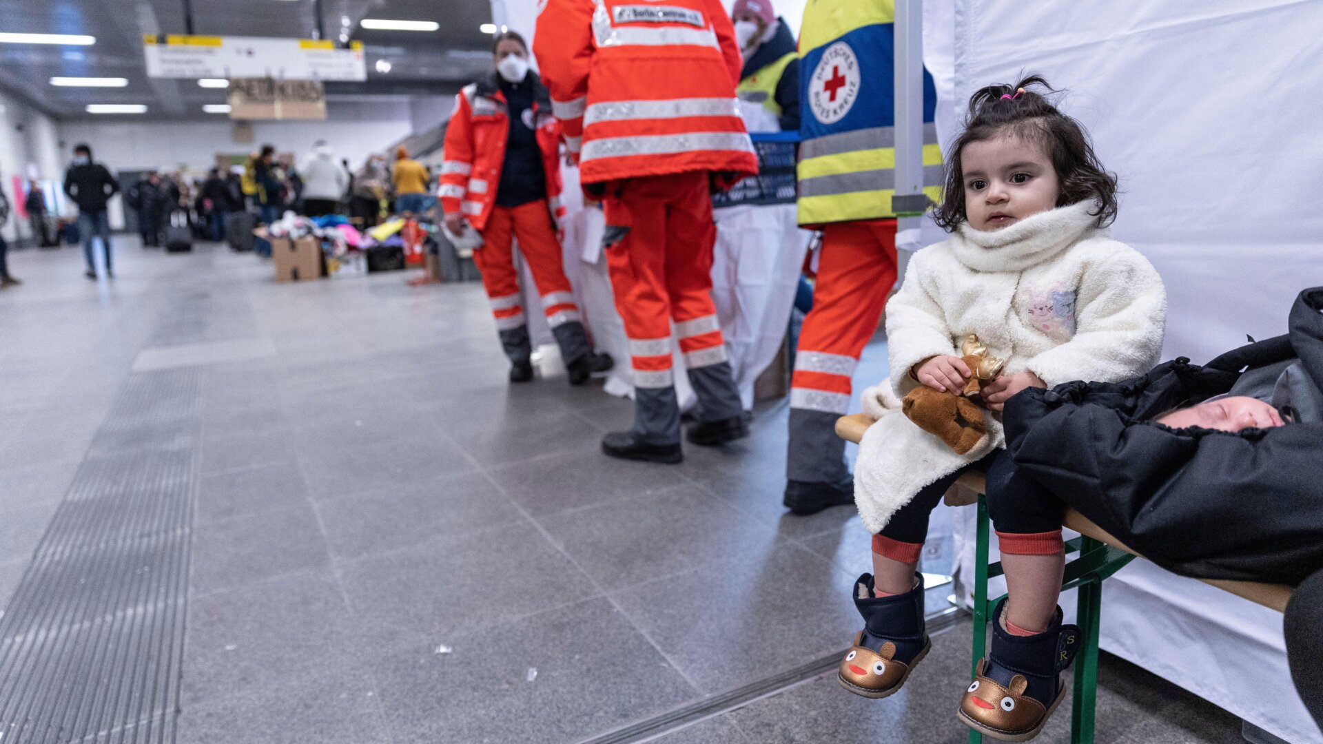 A little girl and a baby wait next to the Red Cross station as people fleeing Ukraine arrive on a train from Poland at Hauptbahnhof railway station on March 4, 2022 in Berlin, Germany.