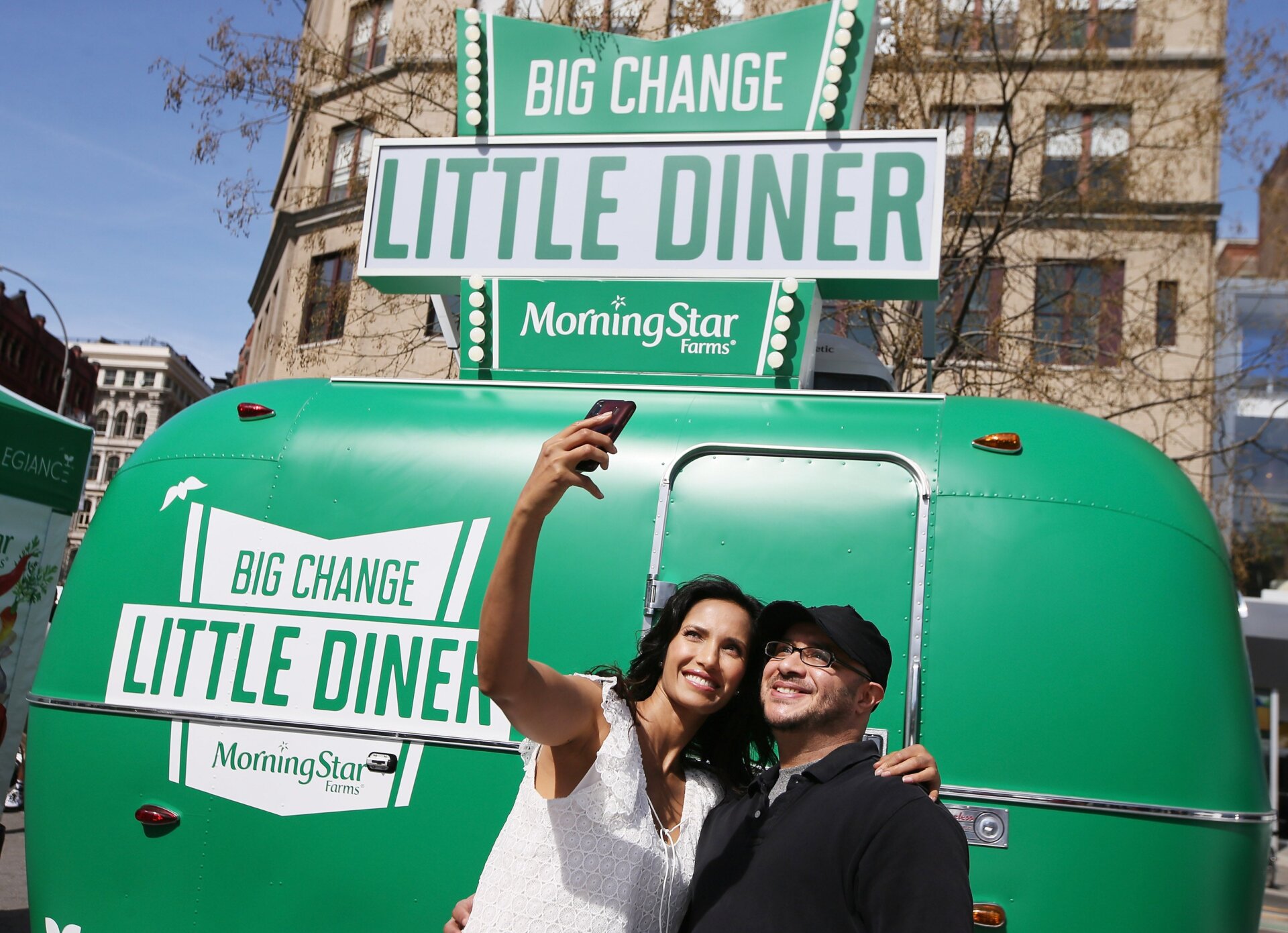 Television host Padma Lakshmi takes a selfie with a fan on April 19, 2015 at an Earth Day event sponsored by MorningStar Farms, a division of the Kellogg Company.