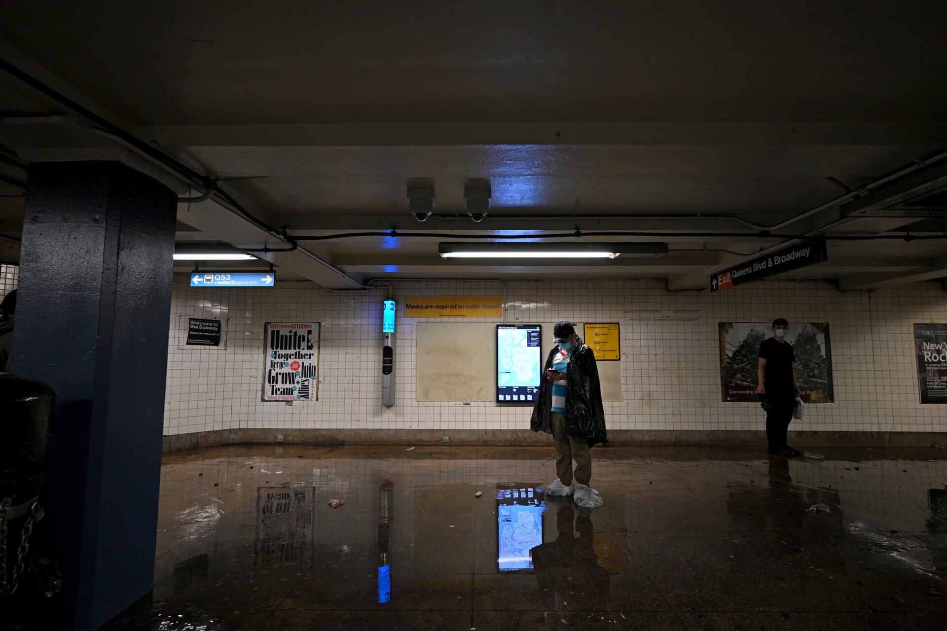 A man wearing plastic bags over his shoes waits for the subway service  to resume as remnants of Hurricane Ida causes flash flooding across the  city, in the New York City borough of Queens, NY, September 1, 2021.