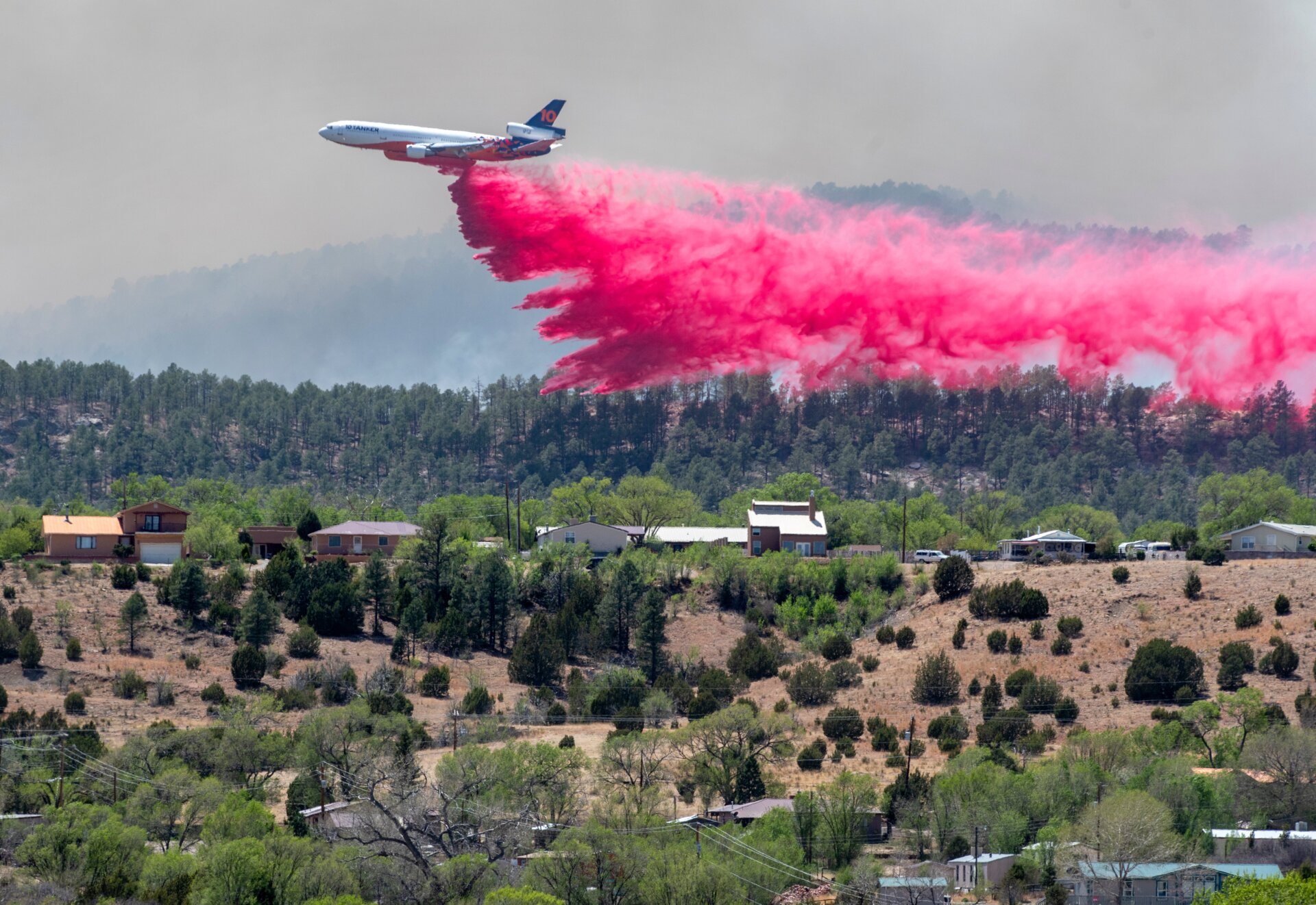 Firefighting aircraft like this slurry bomber (dropping fire retardant) are helping to keep the ongoing Calf Canyon/Hermits Peak fire from burning through Las Vegas, NM.