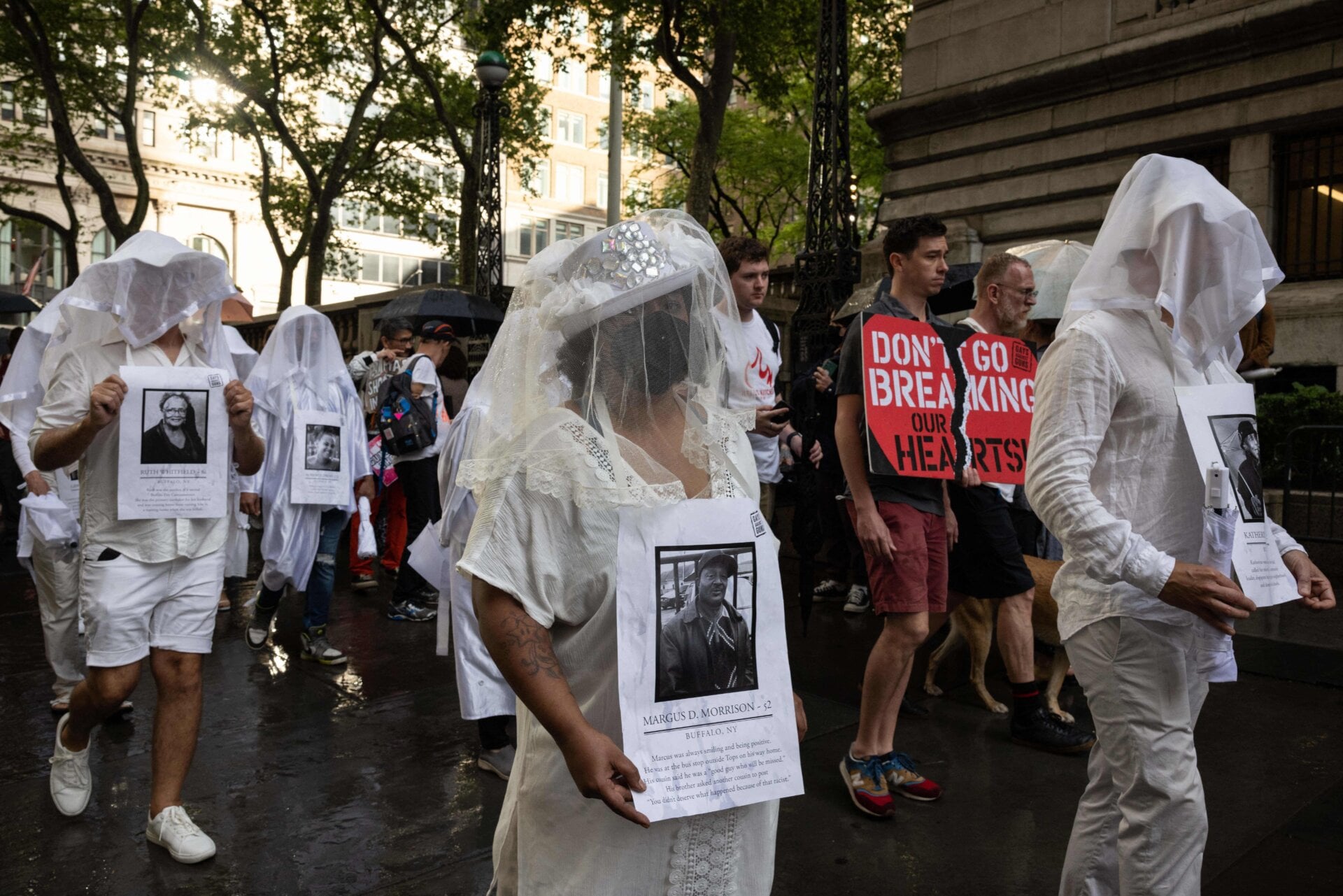 Demonstrators from “Gays against Guns” wear portraits of the Buffalo shooting victims and march in Times Square May 16.