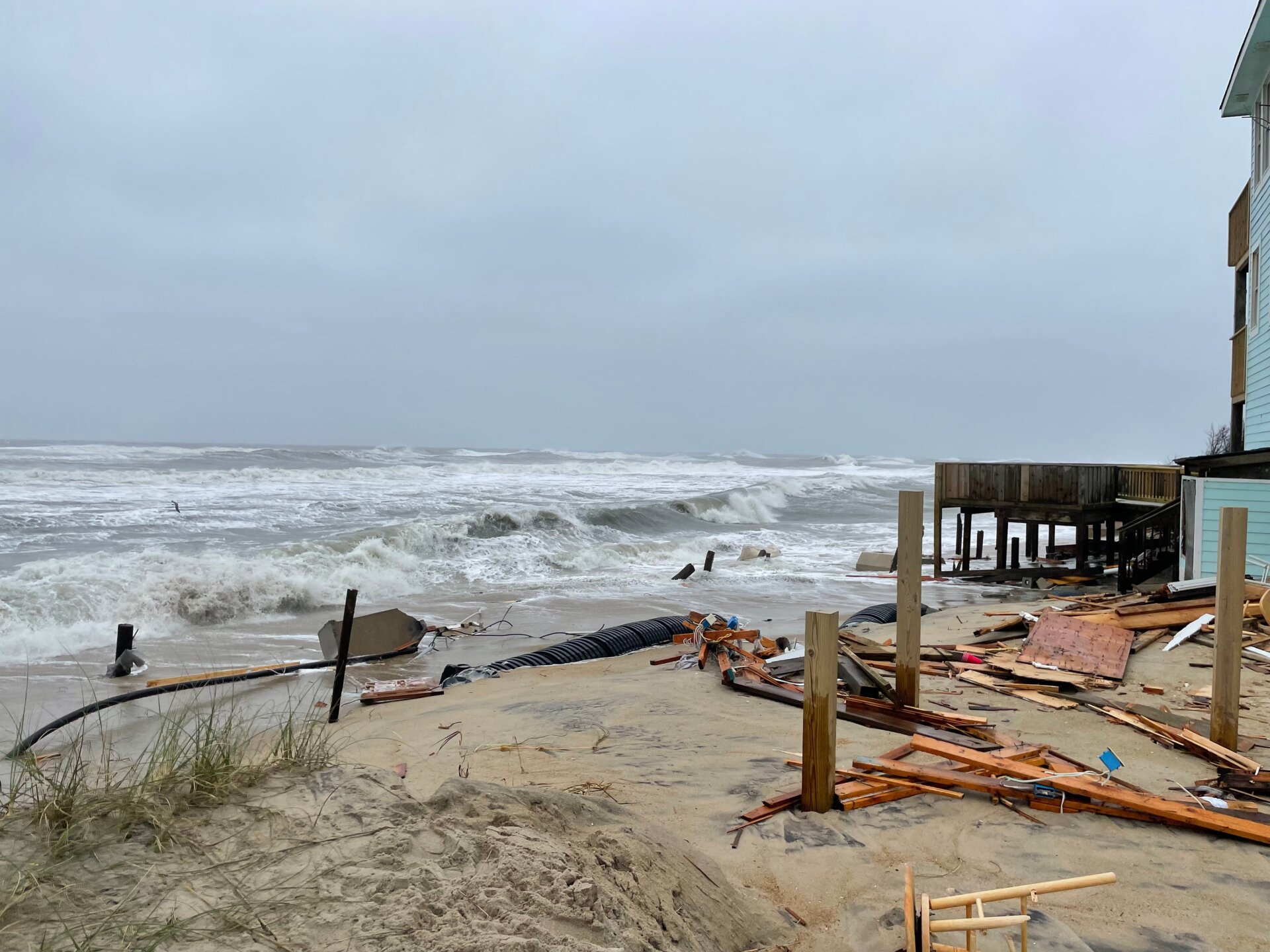 In the aftermath of the house collapses, the beaches are closed for cleanup. Extensive debris, including electrical wiring and septic tank piping, litters the shoreline.