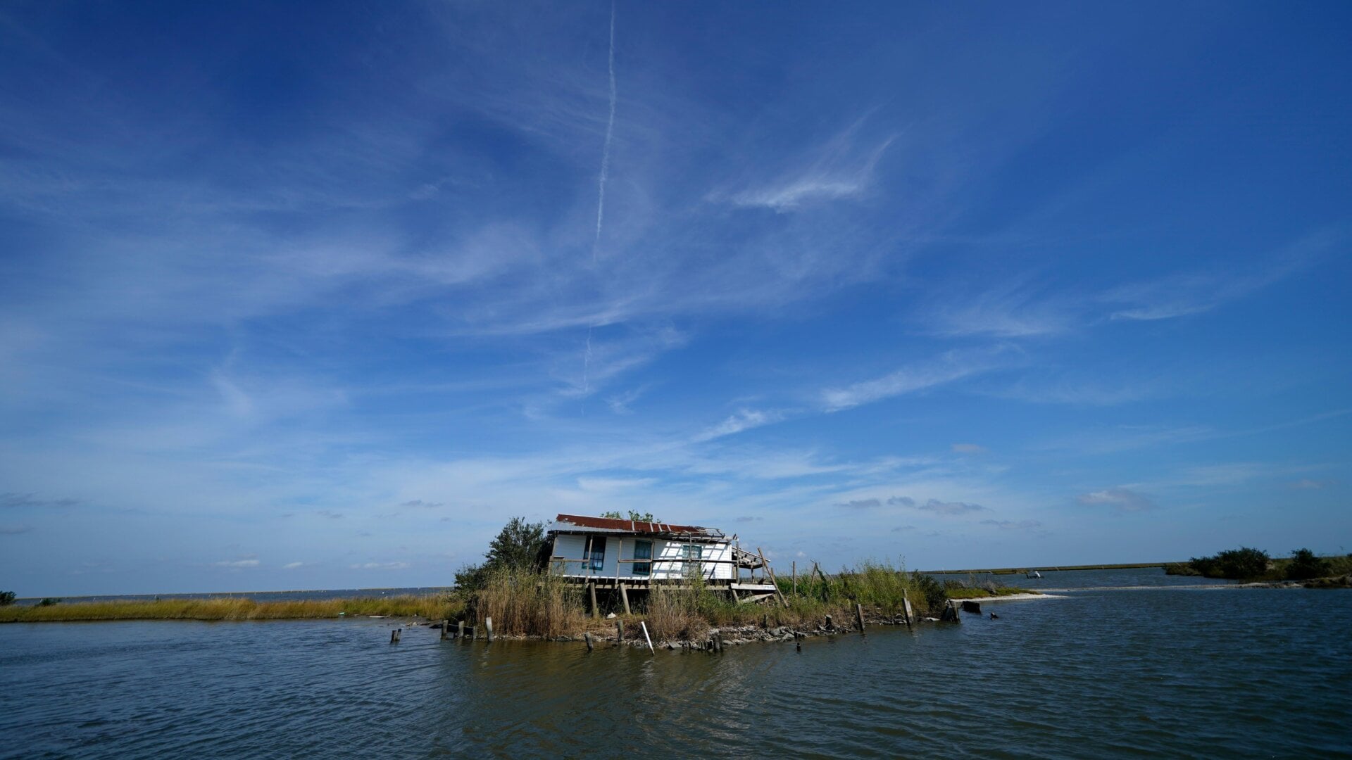 A camp heavily damaged by Hurricane Ida over the summer sits along shoreline that is retreating due to coastal erosion in Plaquemines Parish, La