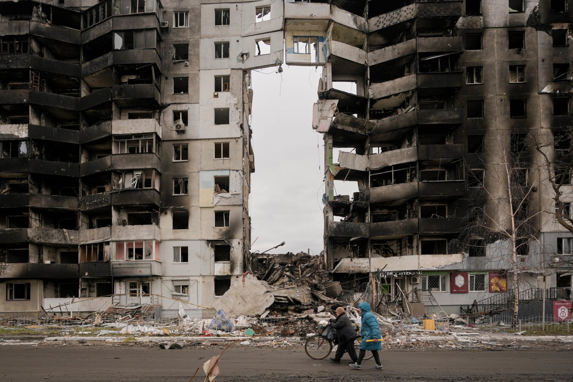 Women carrying food products walk by a destroyed apartment building in Borodyanka, on the outskirts of Kyiv, Ukraine in an area where officials said there were numerous examples of Russian war crimes.