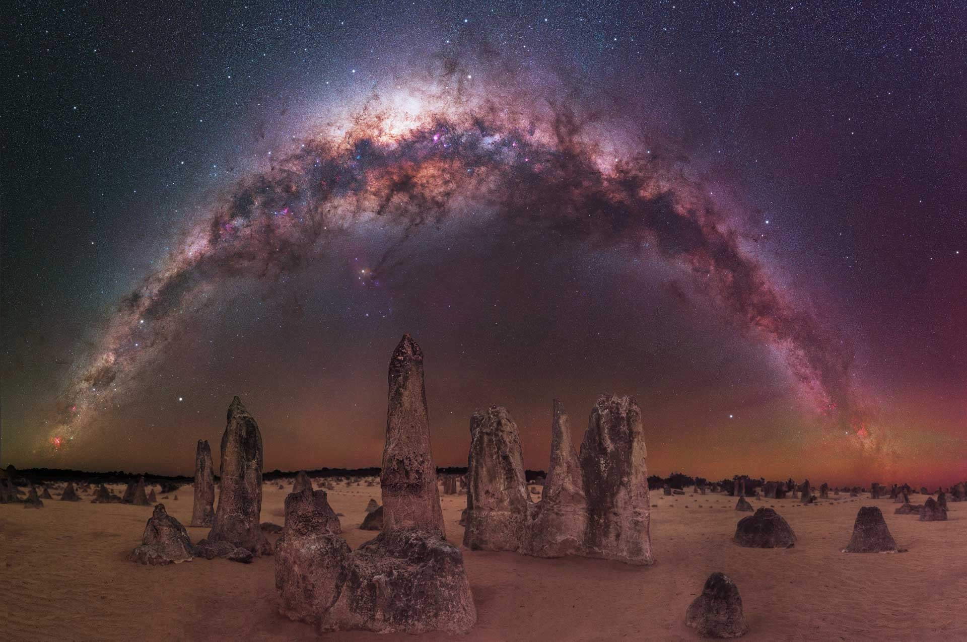 The Milky Way arching over rocks in the Australian desert.