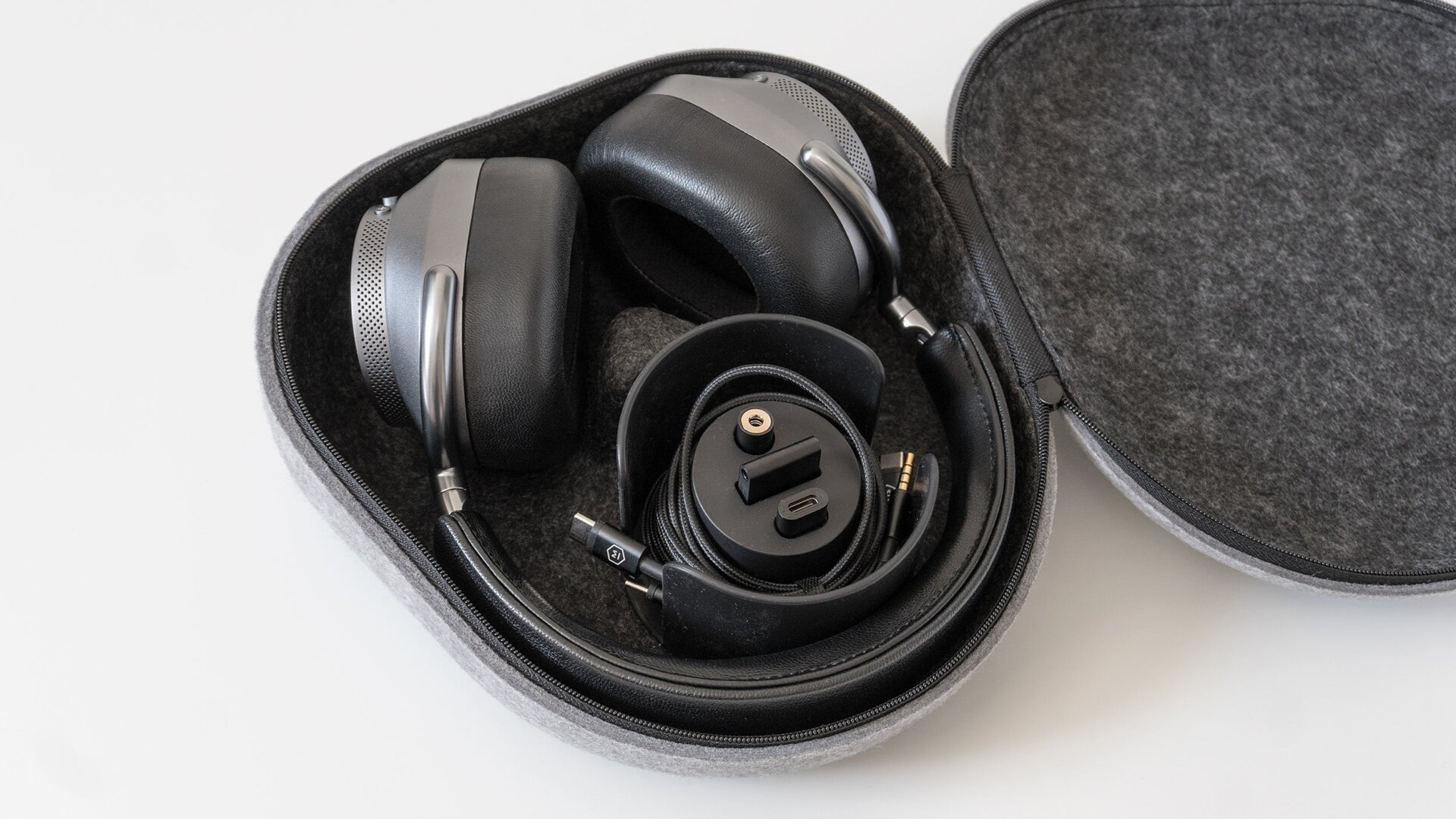 The Master & Dynamic MW75's carrying case includes accessories like a headphone cable, a charging cable, and an adapter for airplane seat headphone jacks.