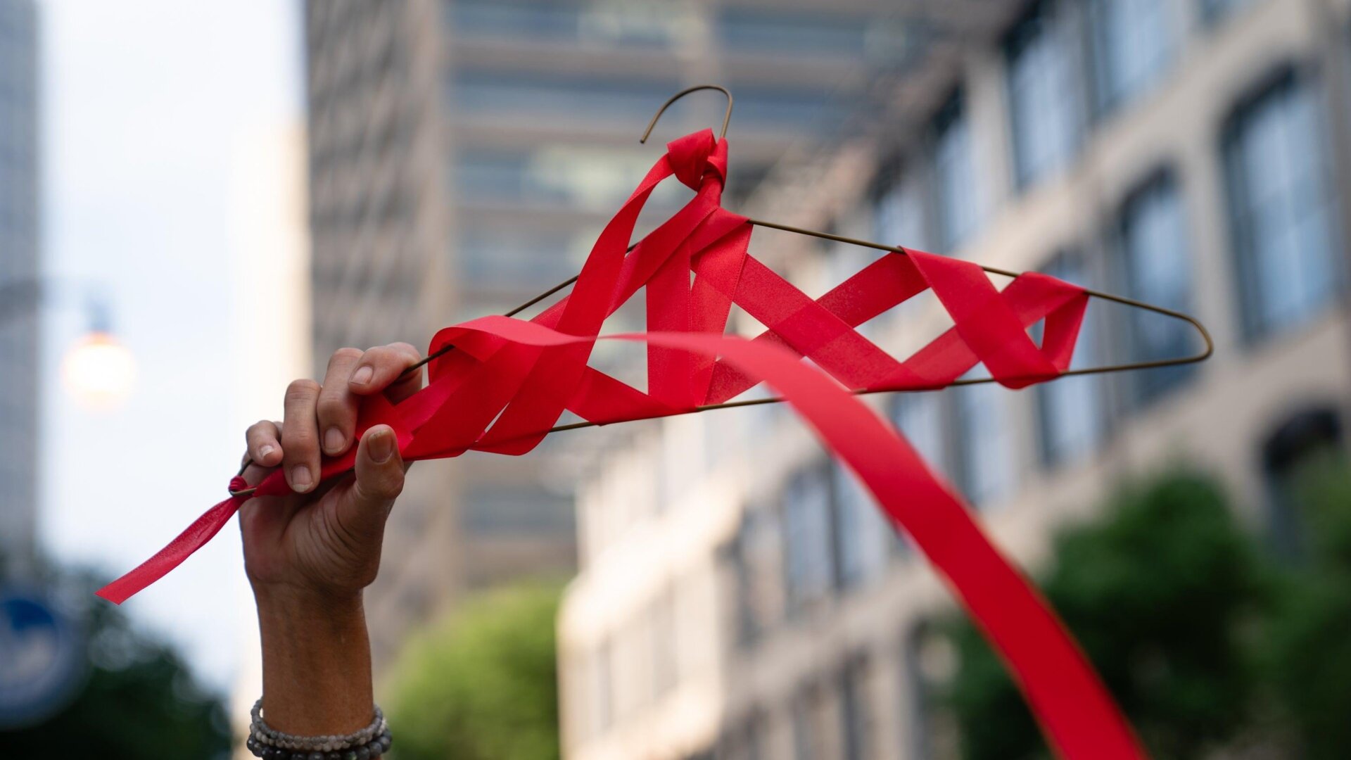 A woman holds up a coat hanger wrapped in red ribbon outside the U.S. Court of Appeals for the Eleventh Circuit during a protest against the Supreme Court’s ruling repealing Roe v. Wade on June 25, 2022 in Atlanta, Georgia.