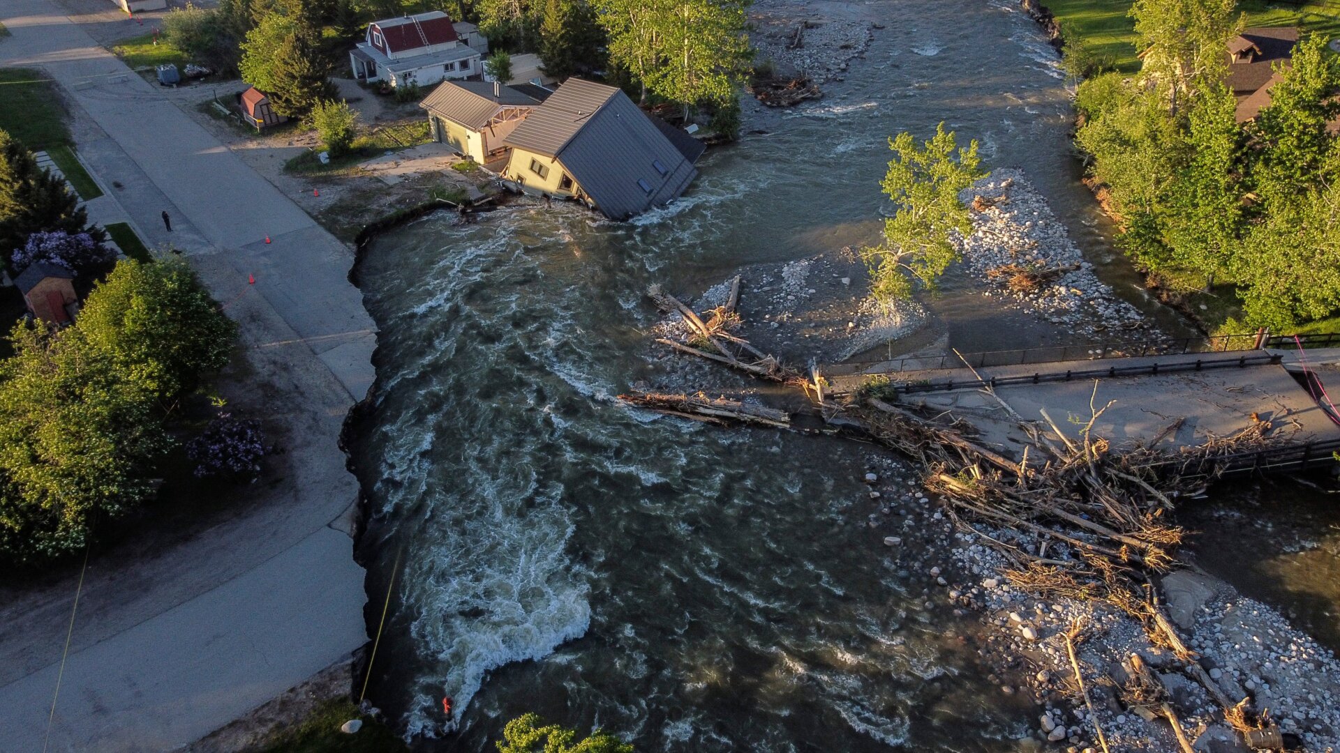 A house sits in Rock Creek after floodwaters washed away a road and a bridge in Red Lodge, Mont., Wednesday, June 15, 2022.